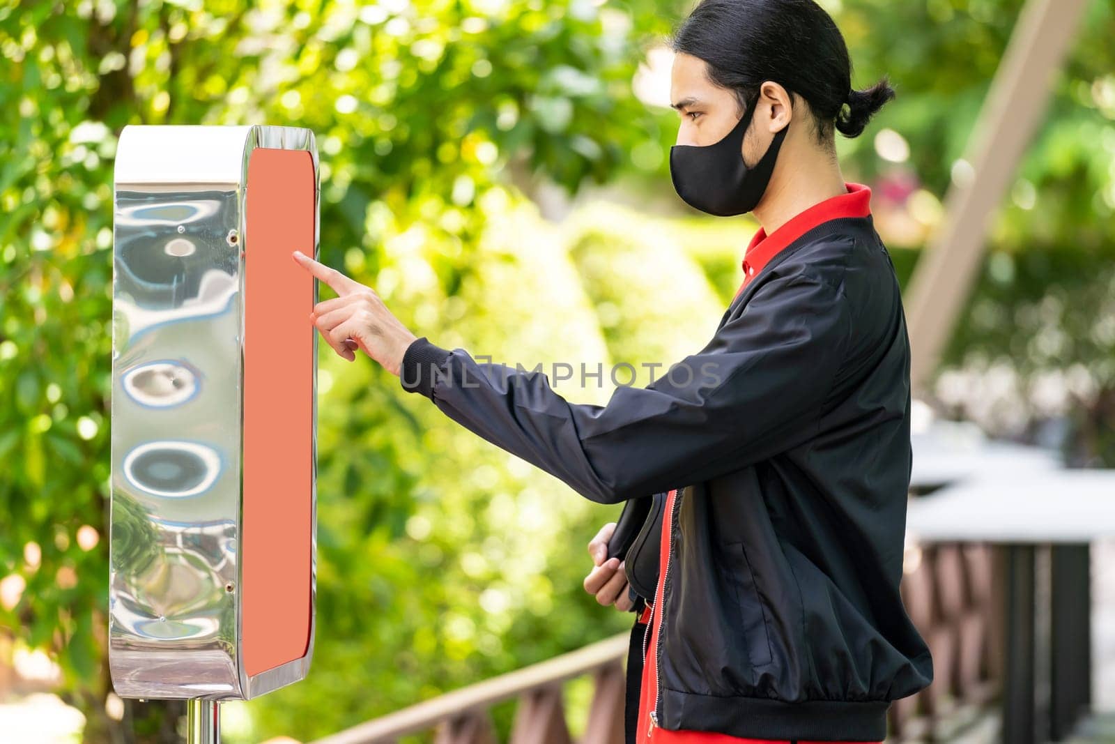 Asian delivery man using kiosk to ordering food and picking up this inline order to customer at fast food restaurant. Online technology self service new normal restaurant concept.
