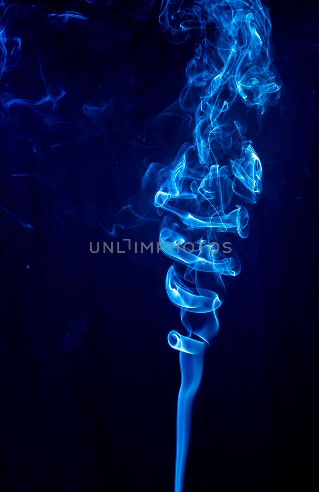 Blue abstract shaped smoke against black background. Abstract background. Selective focus