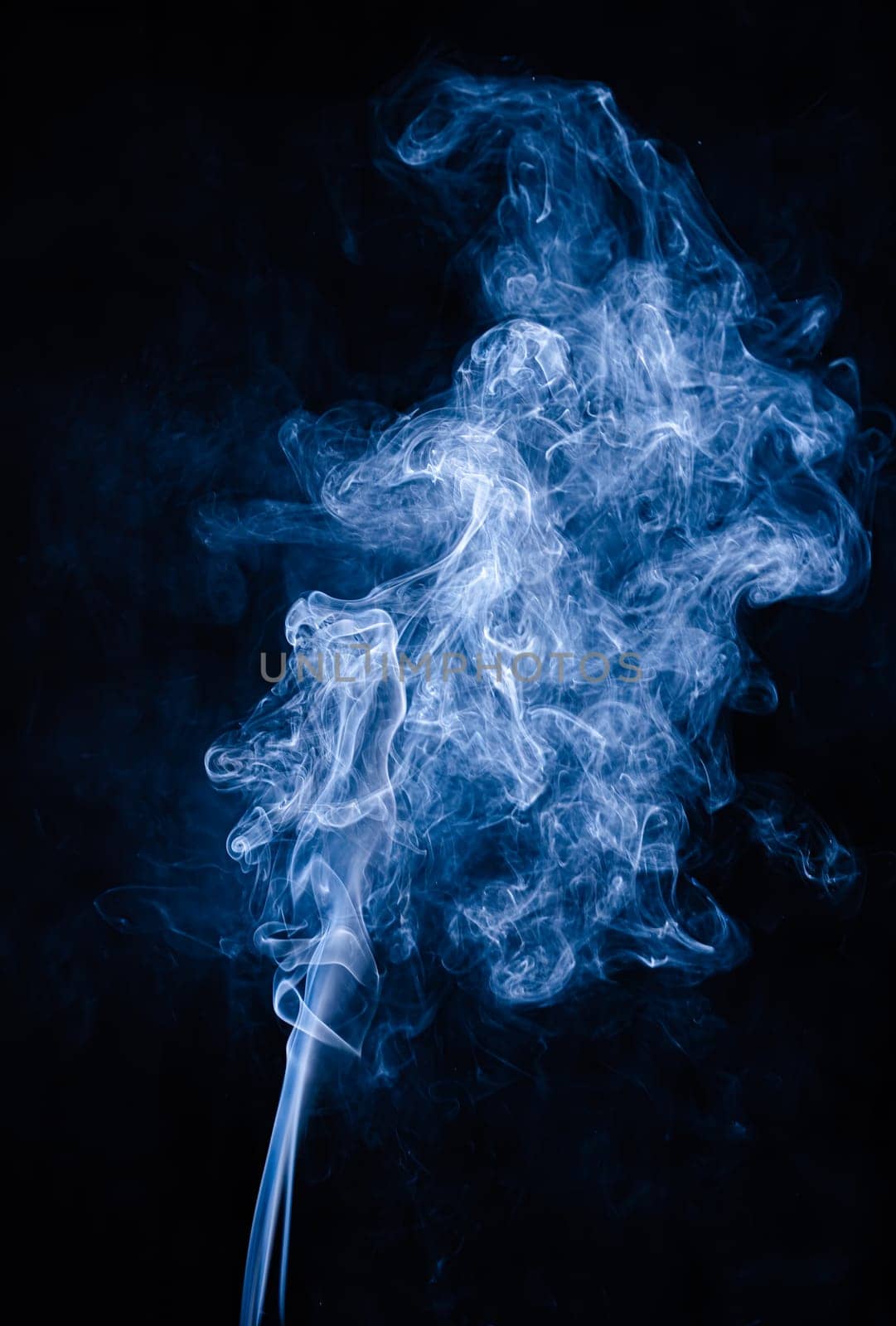 Blue abstract shaped smoke against black background. Abstract background. Selective focus