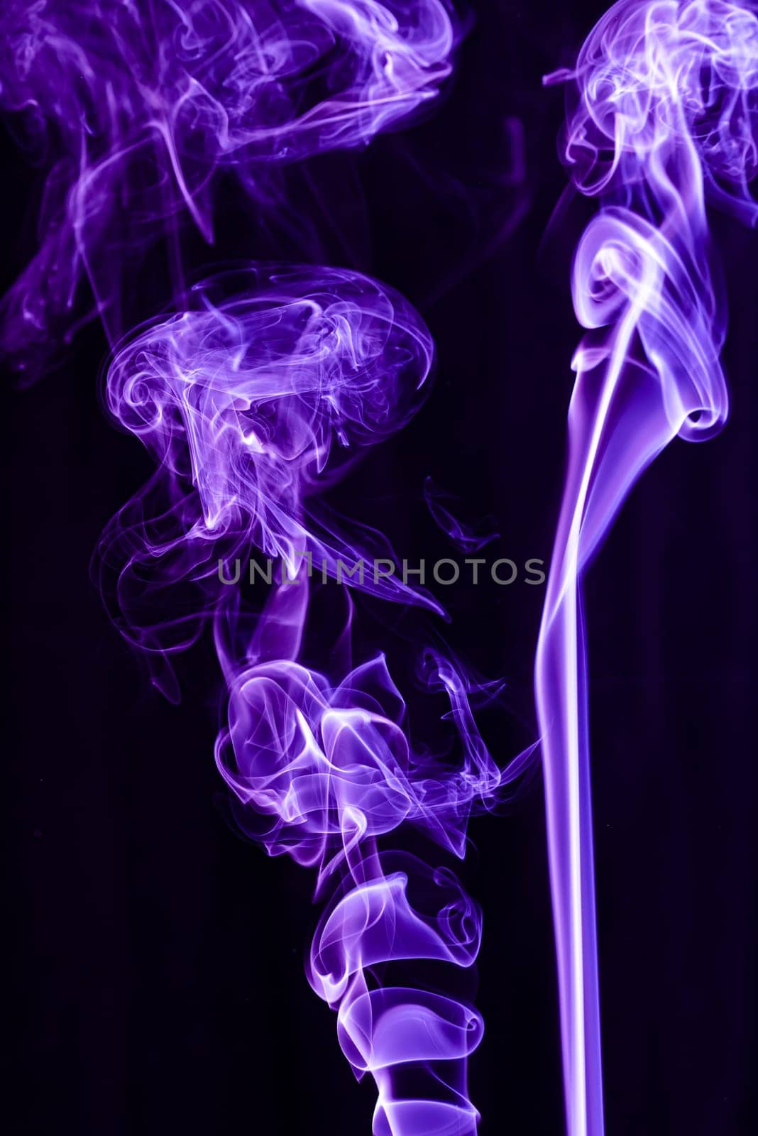 Violet abstract shaped smoke against black background. Abstract background. Selective focus