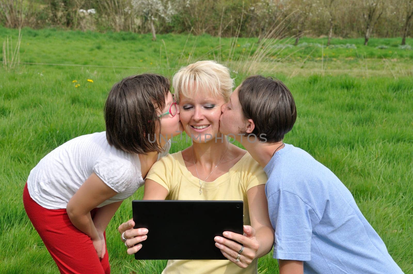 Family sitting on the lawn and using digital tablet