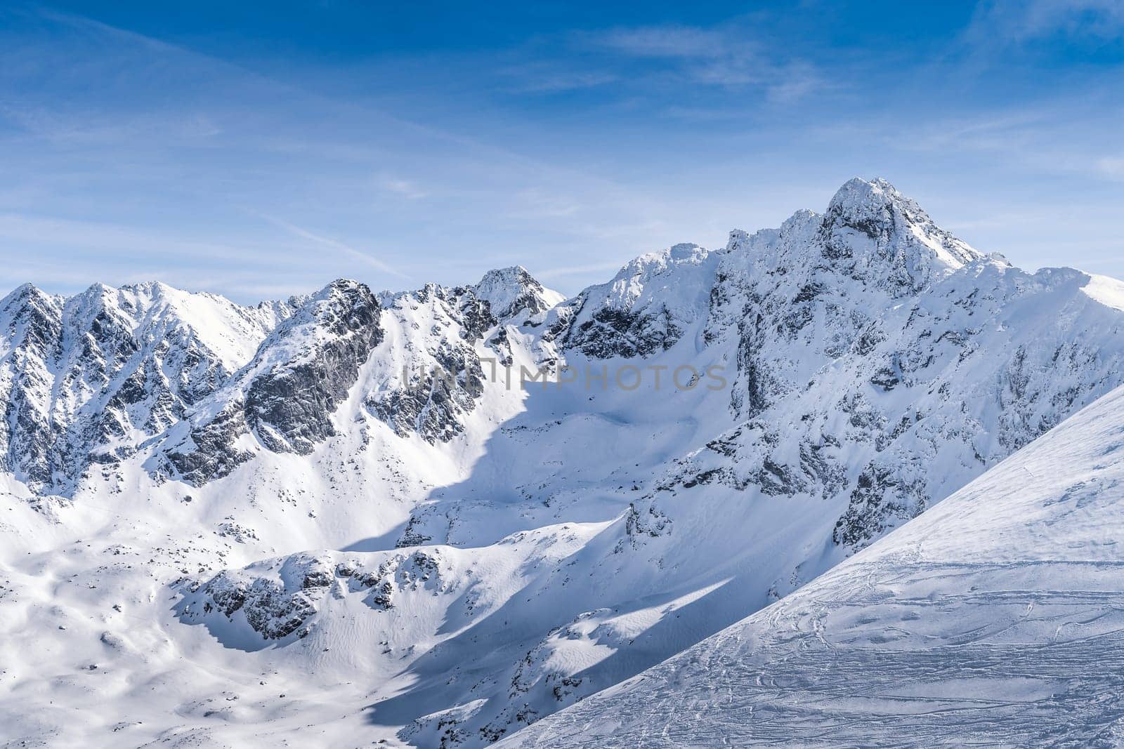 View from Kasprowy Wierch at Swinica mountain peak at winter. Amazing mountain range with snow capped mountain peaks in Tatra Mountains, Poland