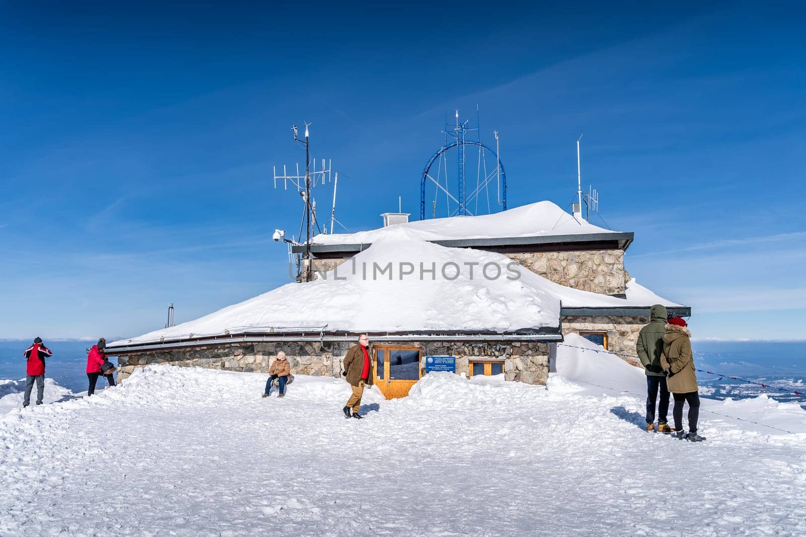 Zakopane, Poland March 2019 Tourists sightseeing the tope of Kasprowy Wierch with multiple meteorologic station in background