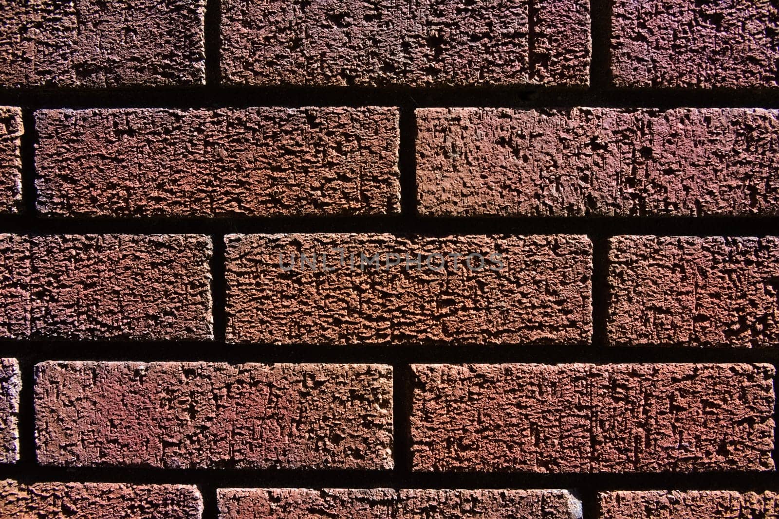 1 - Horizontal red brick wall background texture. Monochromatic appearance and dark shadows between the bricks.
