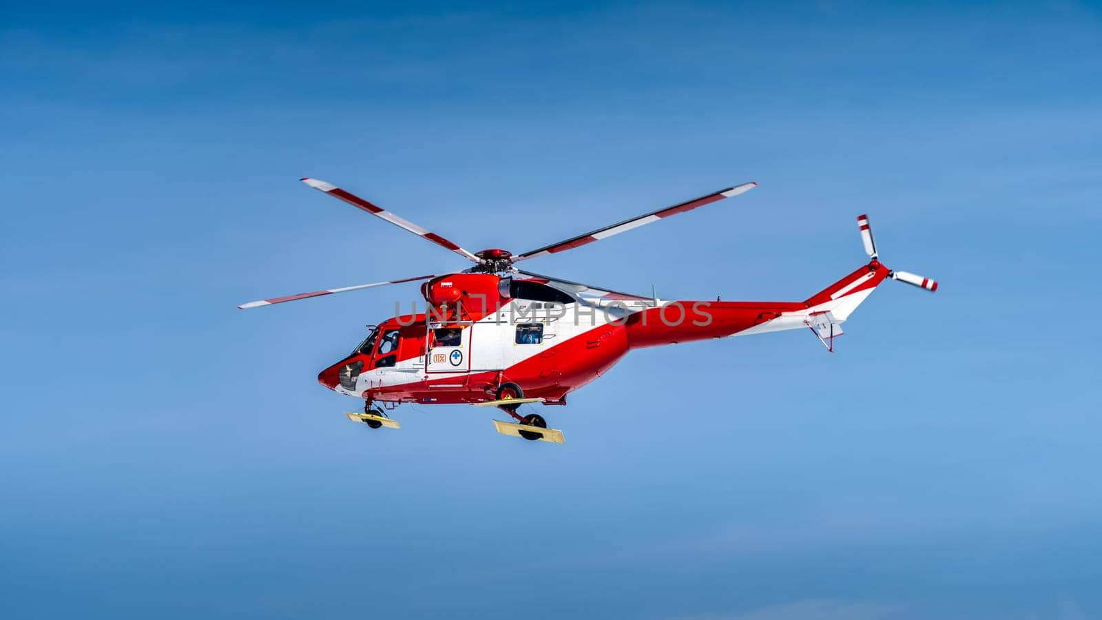 Red and White helicopter, rescue team or crew flying over Kasprowy Wierch and Swinica in High Tatra Mountains, providing rescue service, Poland