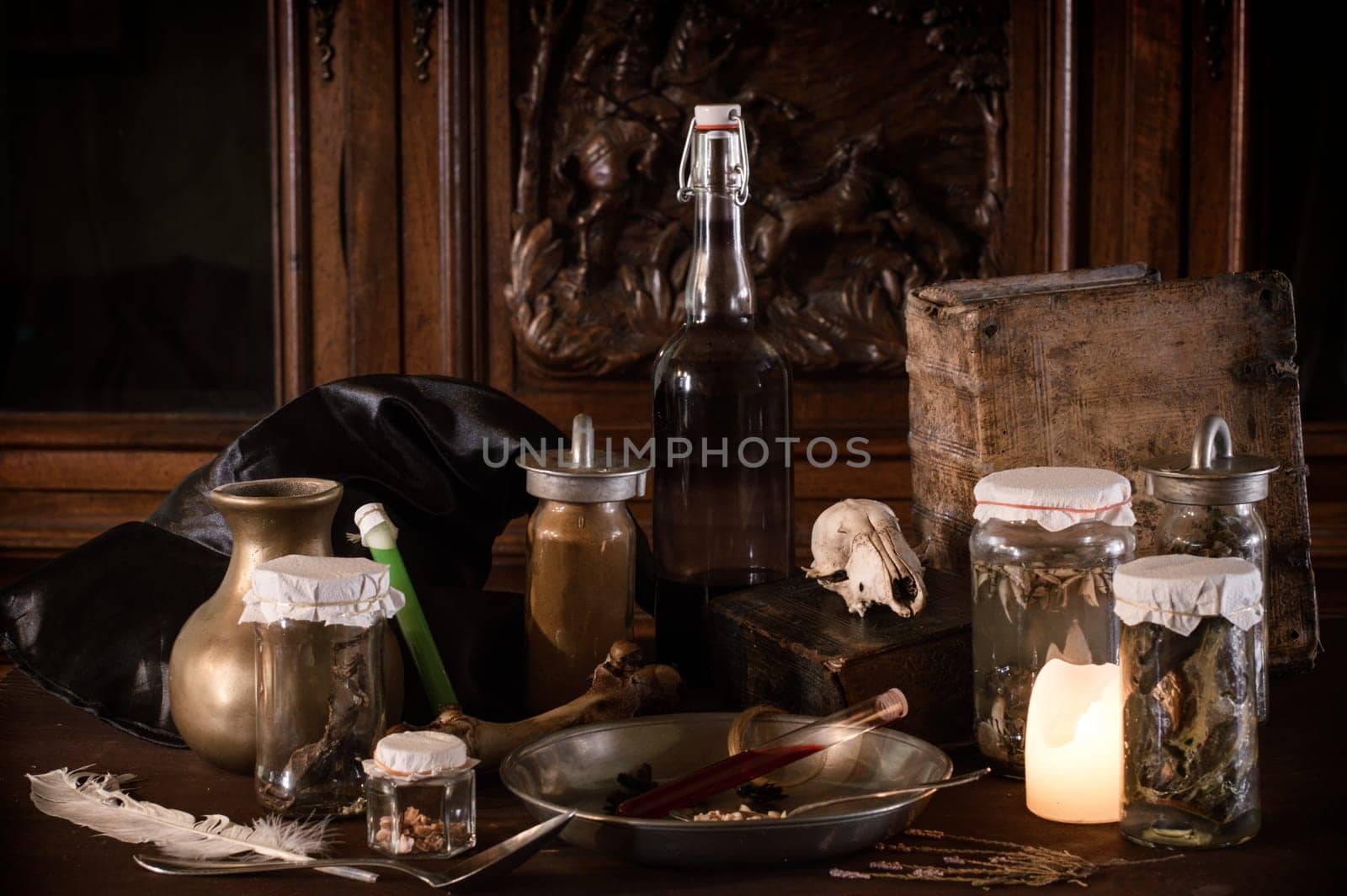 eerie witches' kitchen with lot of ingredients for a potion and ancient gruesome jars dark with only candlelight for Halloween