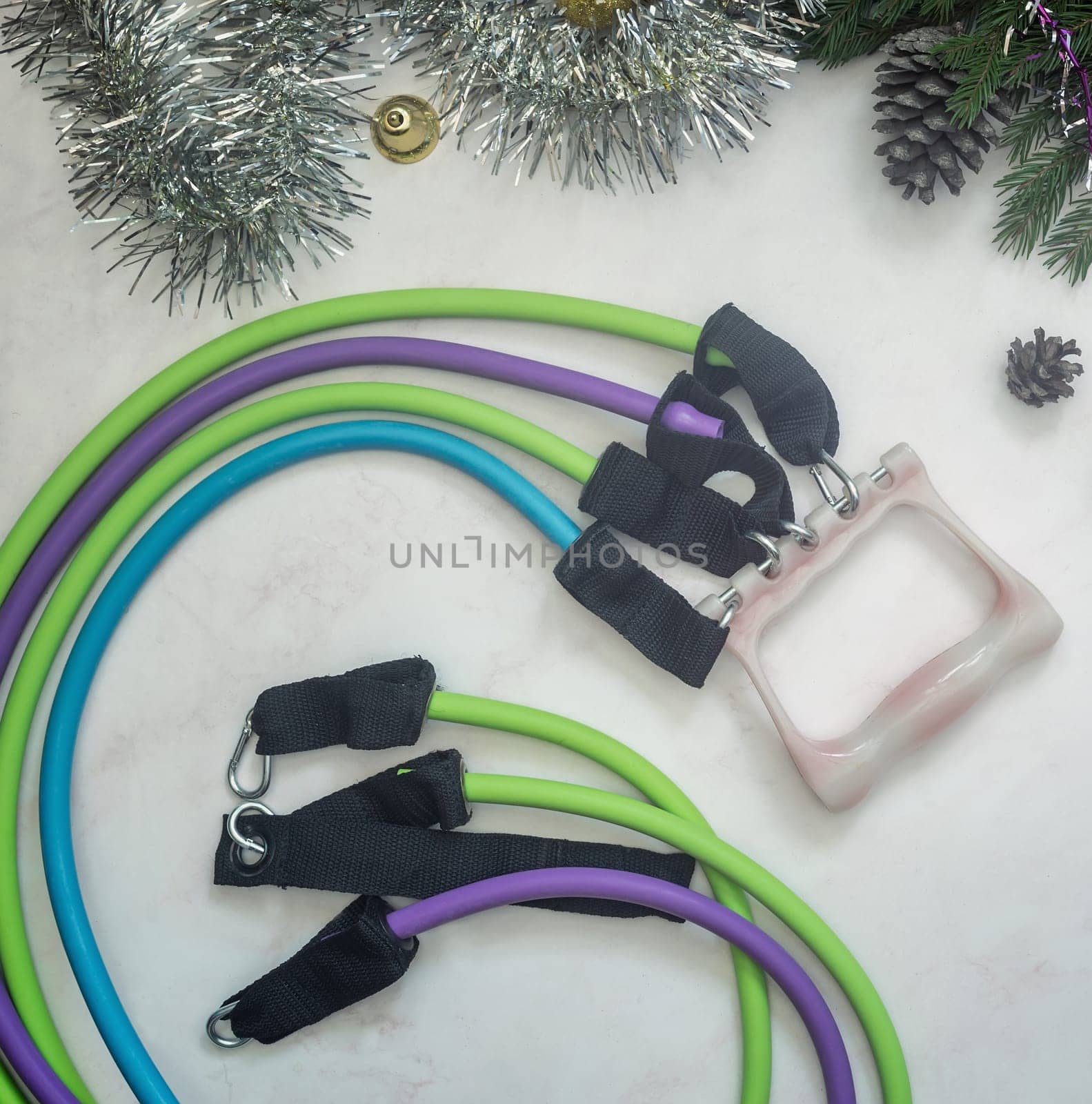 Set of expanders and Christmas decorations on a light background. Greeting card with the concept of a healthy lifestyle. Sports and fitness. Top view with space to copy. Flat lay.