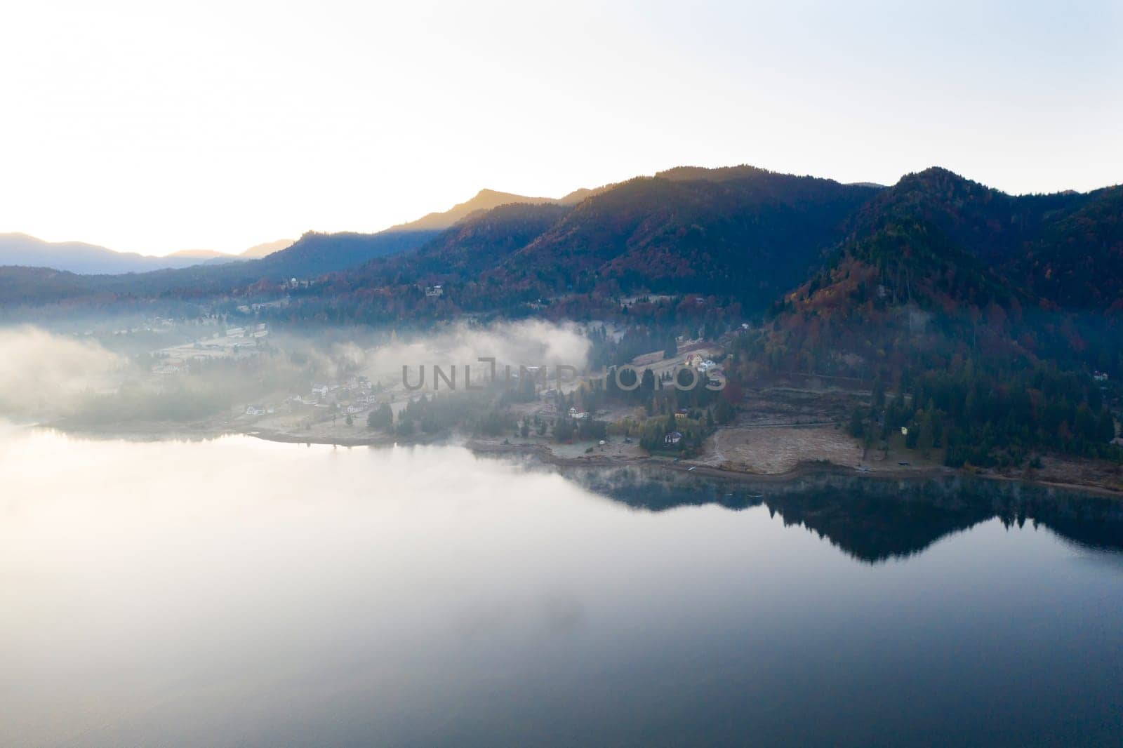 Magic foggy sunrise over Colibita lake at autumn, Romania.