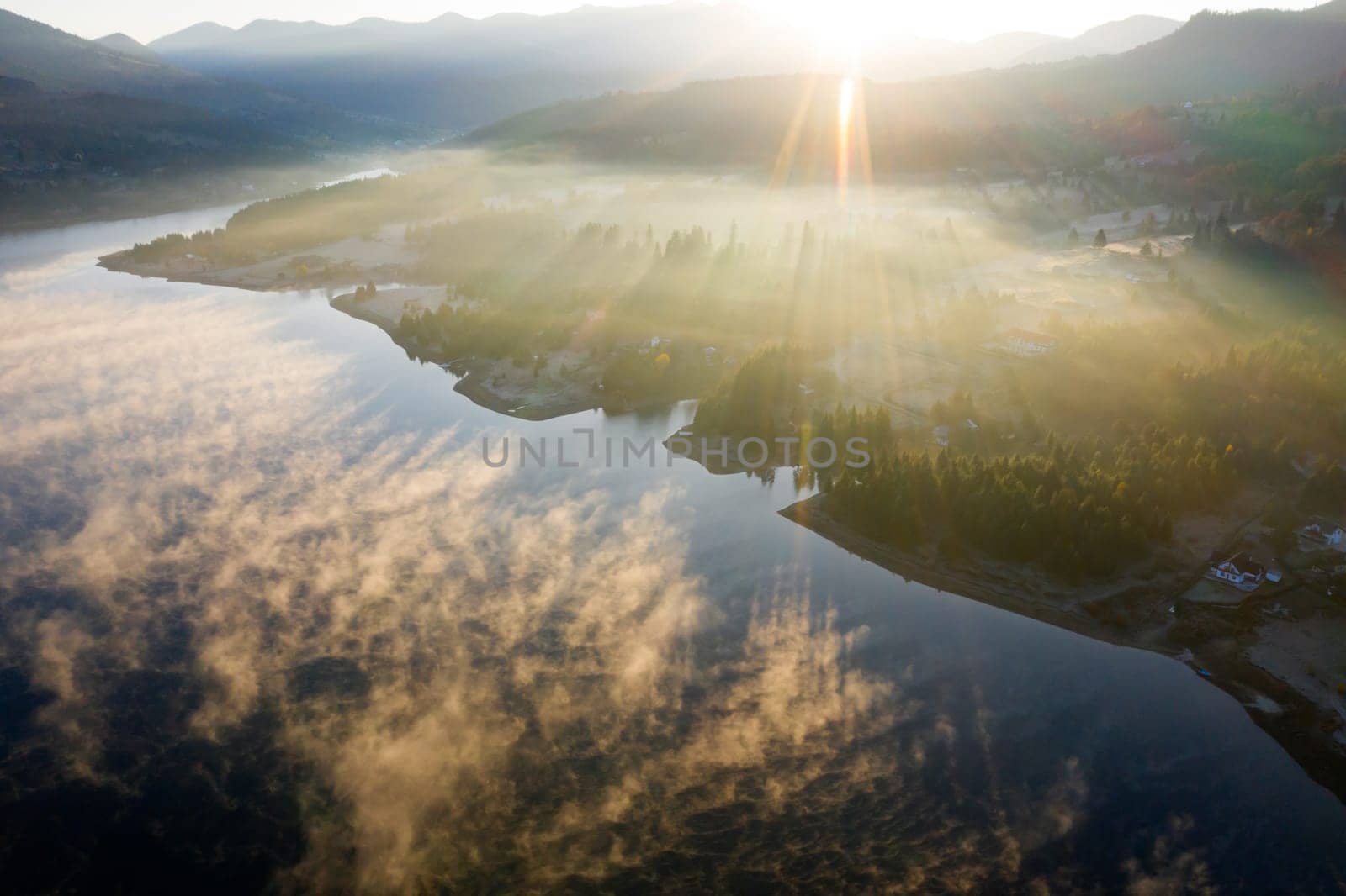 Magic foggy sunrise over Colibita lake at autumn, Romania.