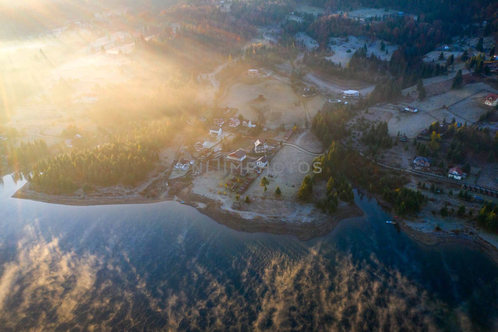 Magic foggy sunrise over Colibita lake at autumn, Romania.