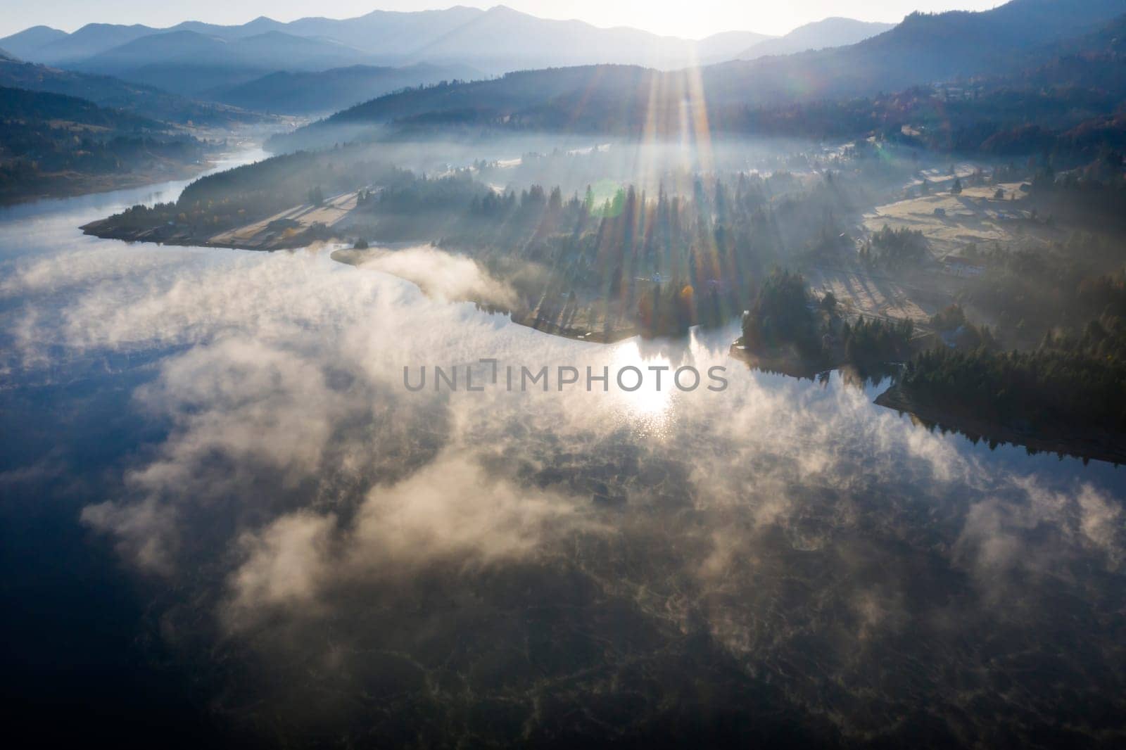 Magic foggy sunrise over Colibita lake at autumn, Romania.
