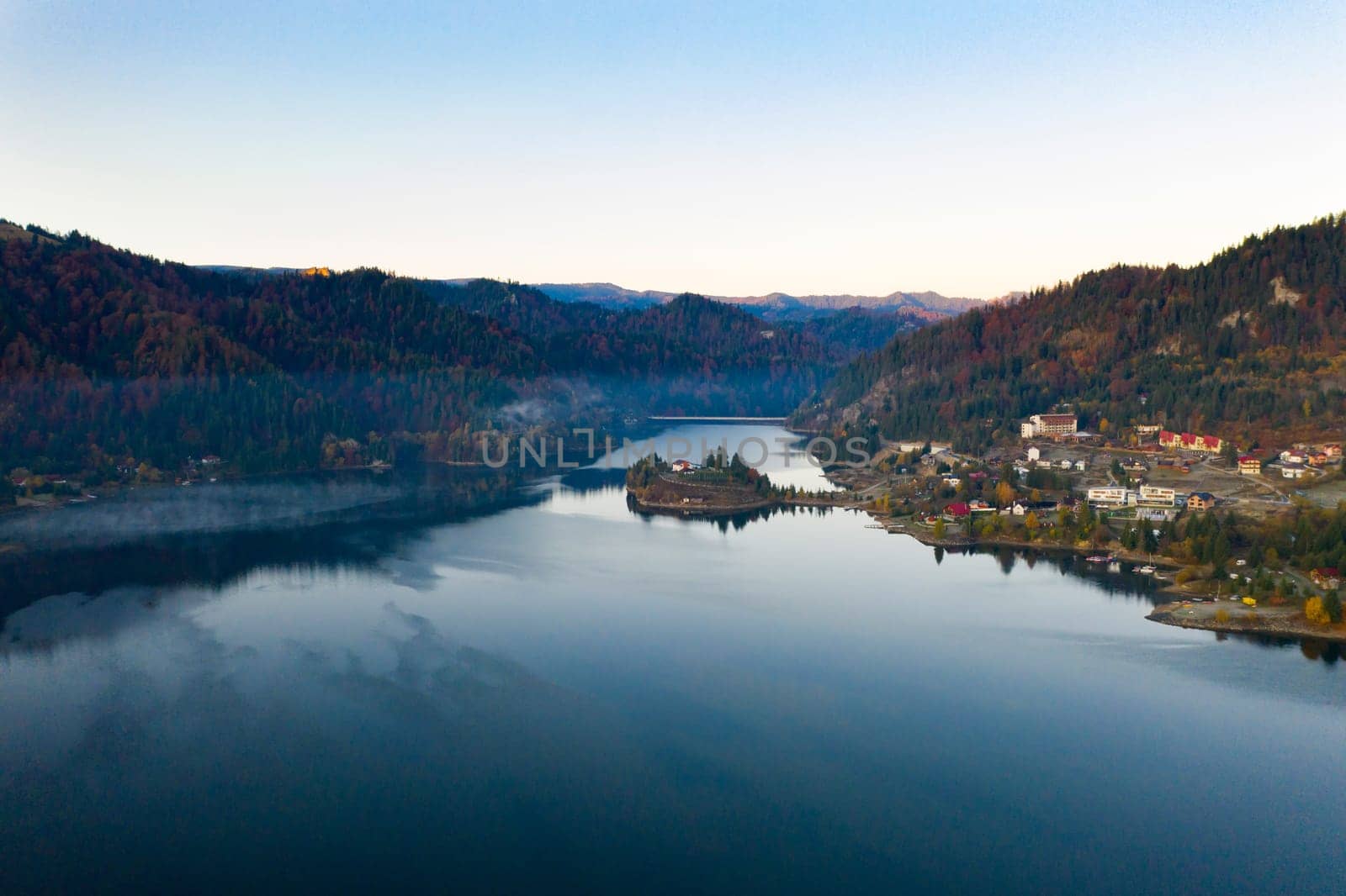 Magic foggy sunrise over Colibita lake at autumn, Romania.
