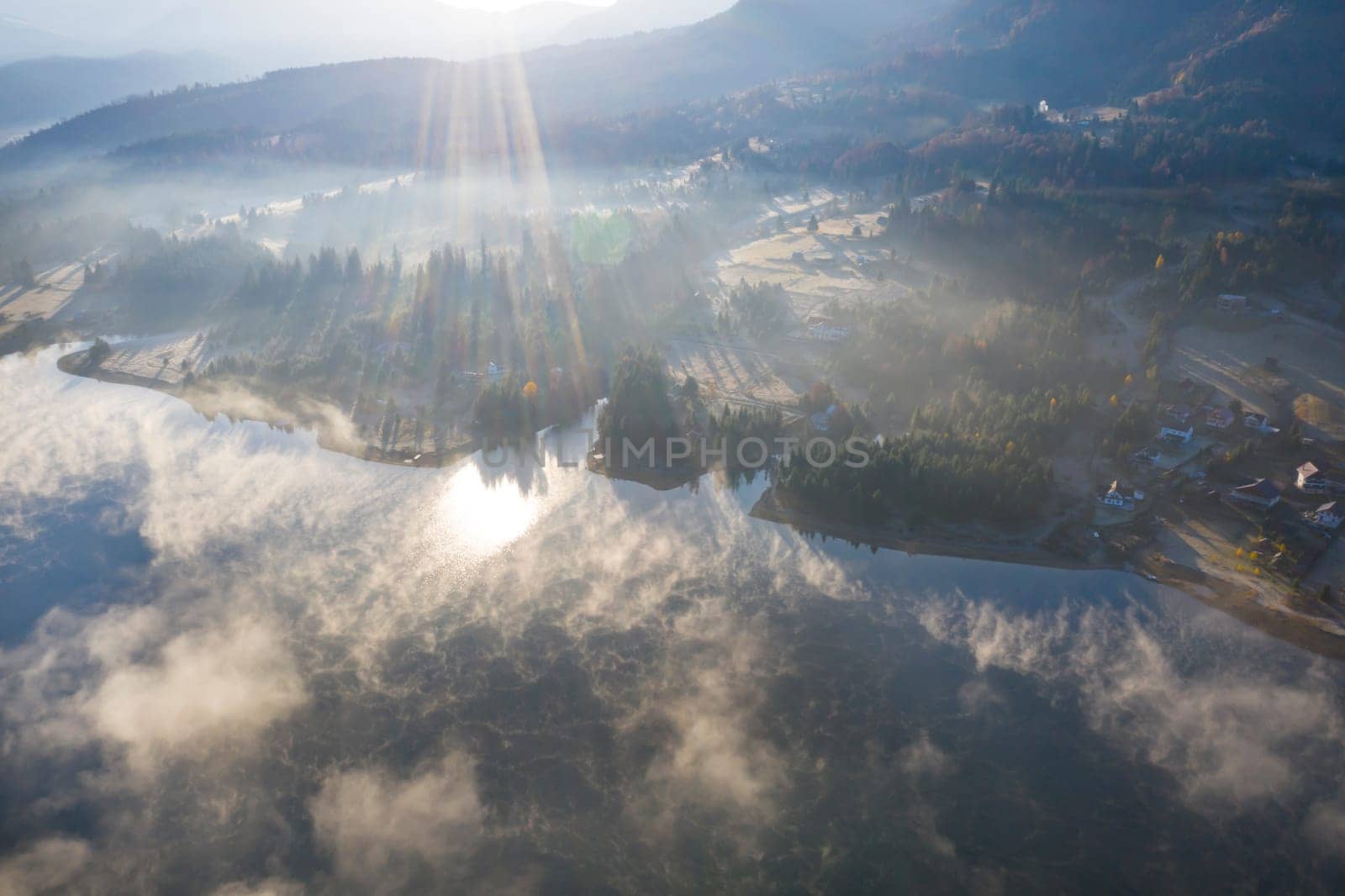 Magic foggy sunrise over Colibita lake at autumn, Romania.