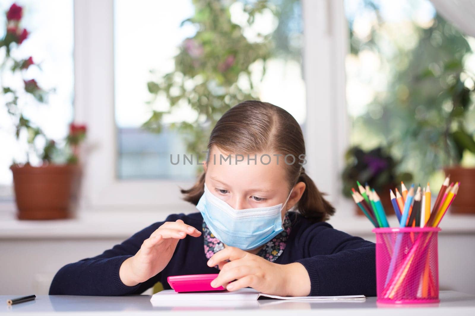 School child wearing mask for protection against coronavirus in school. Measures to prevent the spread of COVID-19 at schools during coronavirus pandemic.