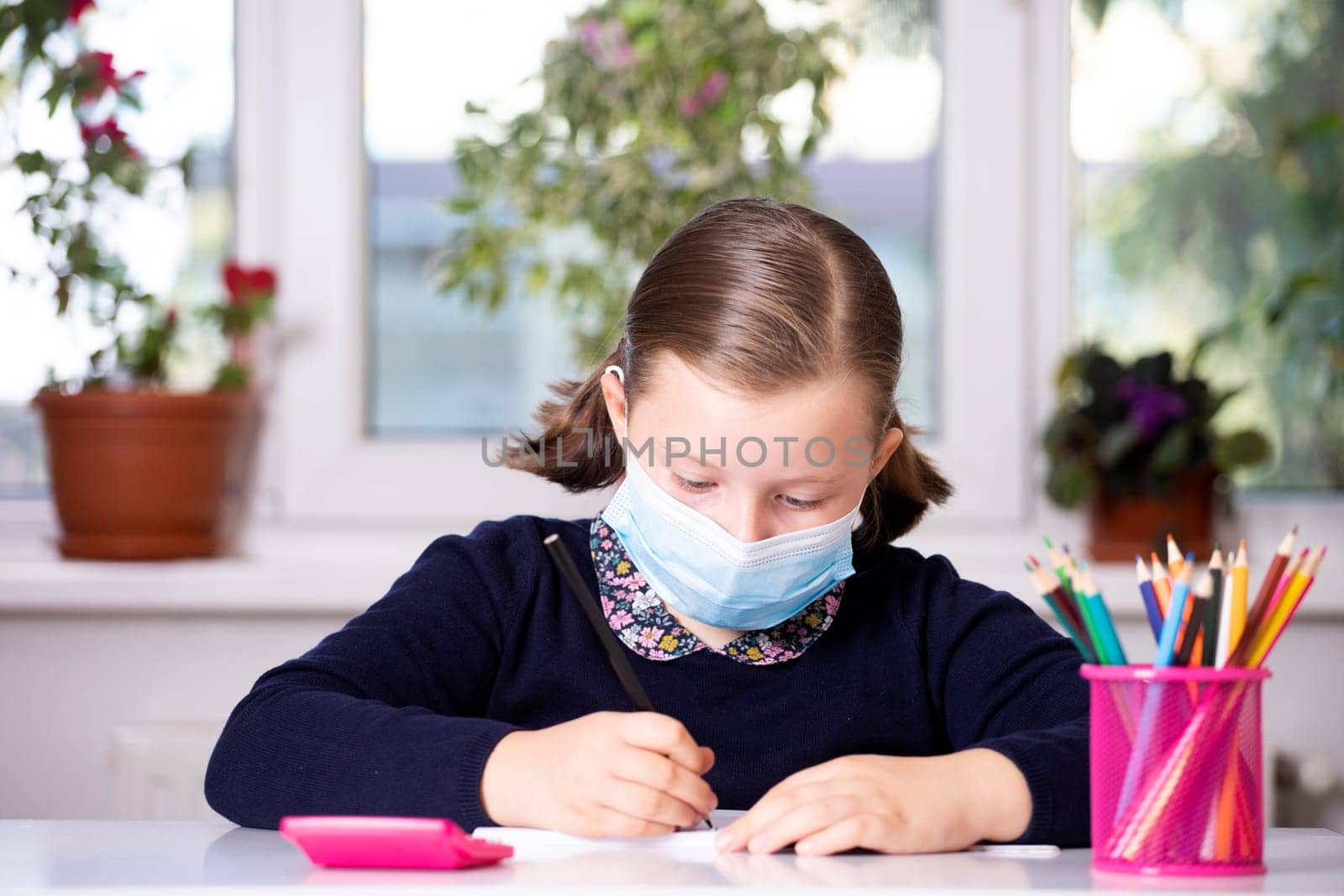 School child wearing mask for protection against coronavirus in school. Measures to prevent the spread of COVID-19 at schools during coronavirus pandemic.