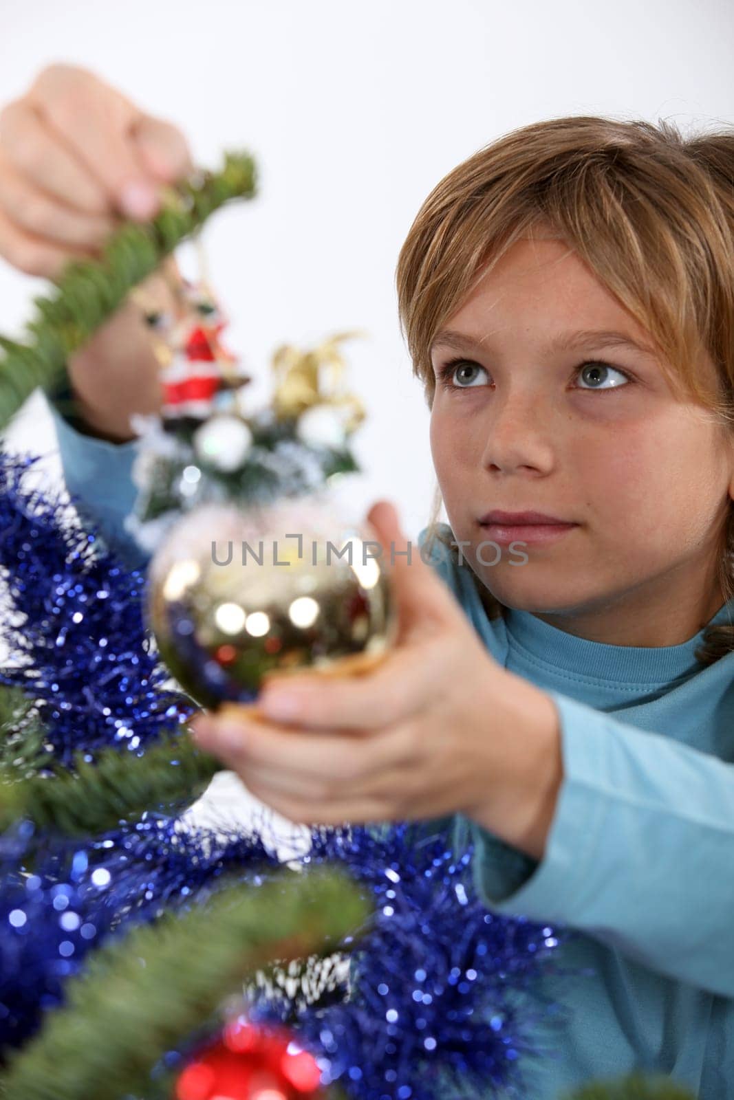 Little boy hanging decorations on Christmas tree