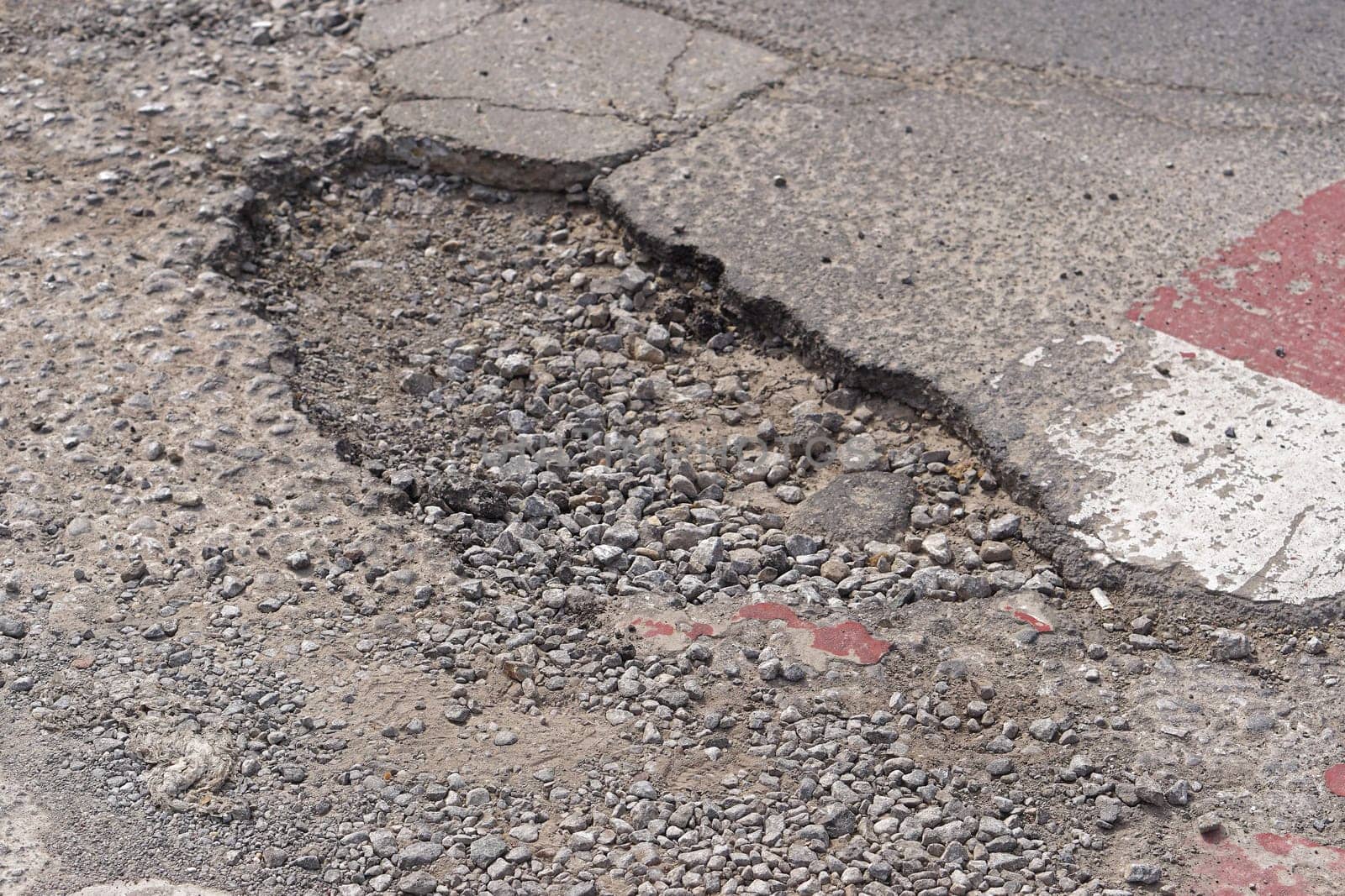 Very big and deep pothole in tarmac at street