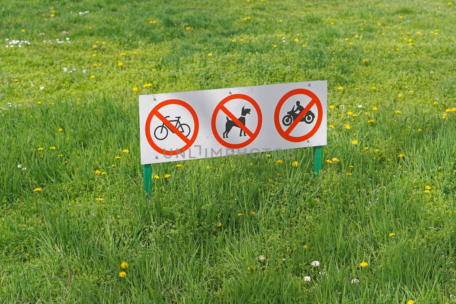 Restrictions signs board at green grass in park