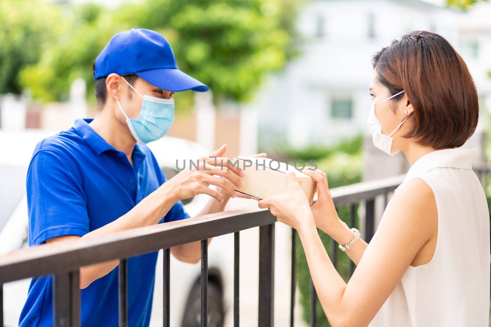Asian Young adult in car holding disposable bag for take out food from drive thru service restaurant. Drive thru is new normal and popular service after coronavirus covid-19 pandemic.