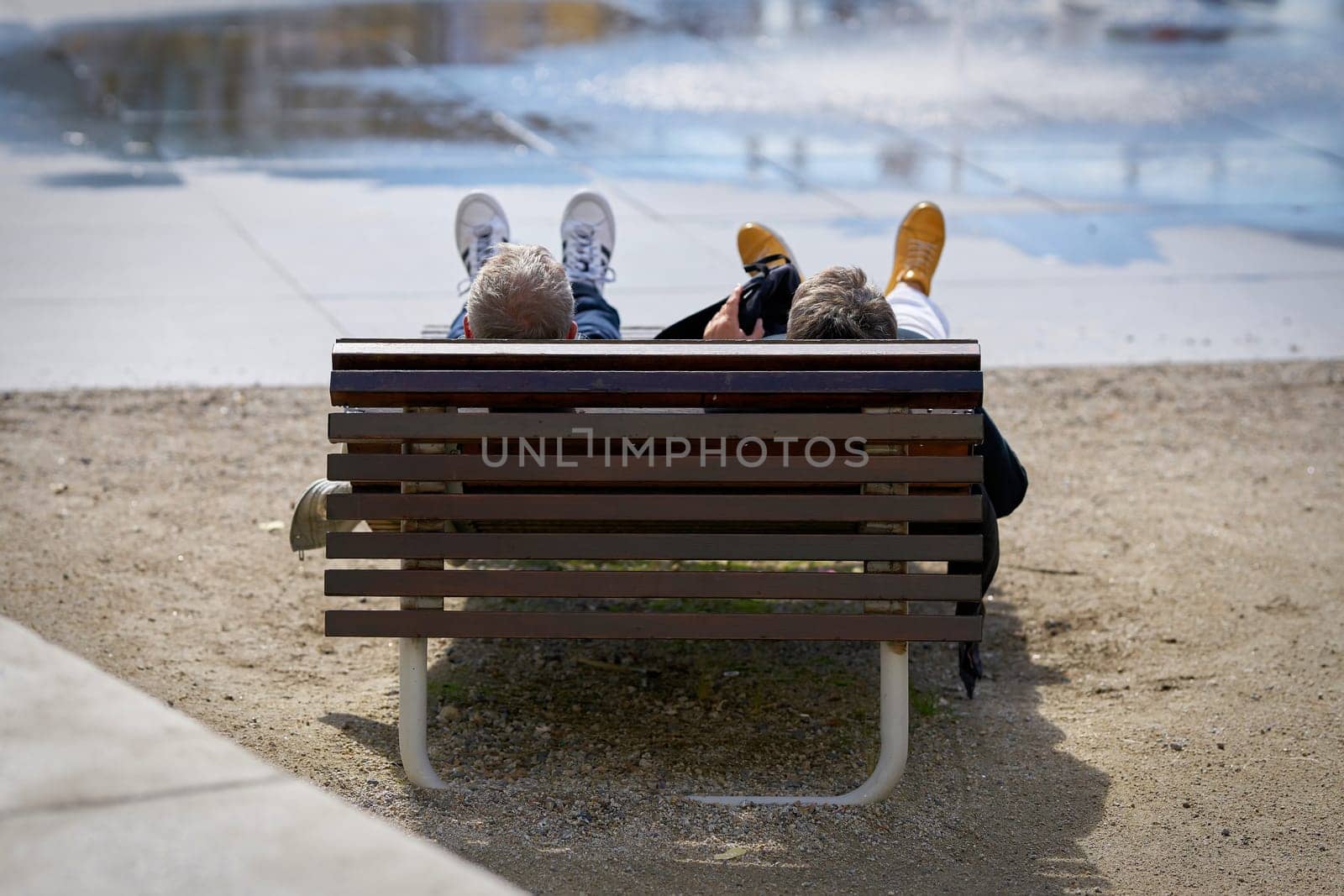 lying relaxed couple on a park bench in the centre of Swinoujscie in Poland