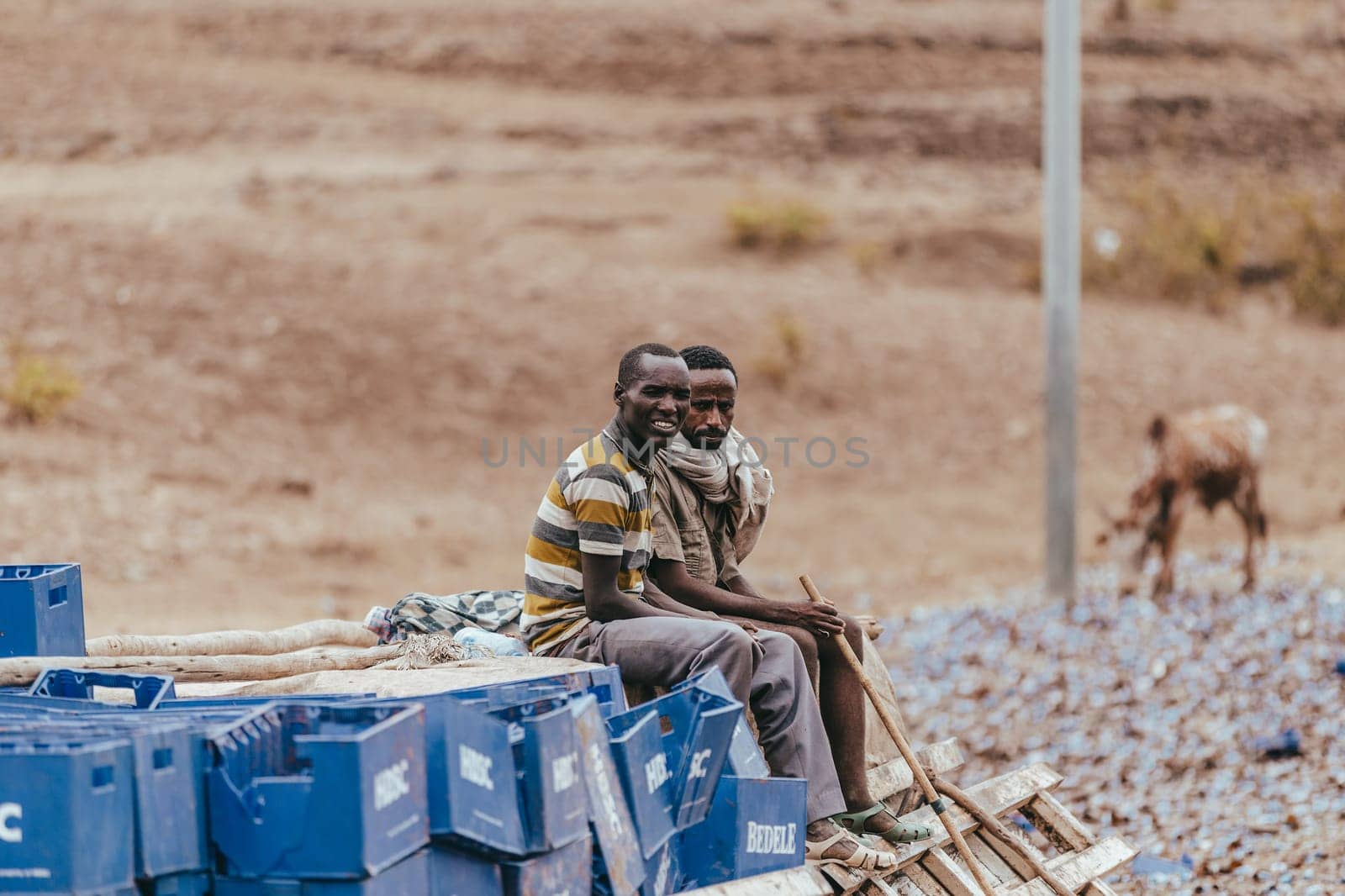 GONDAR, ETHIOPIA, APRIL 22.2019, Truck drivers sitting on spilled cargo after accident on a country road. Gondar, Ethiopia, April 22. 2019