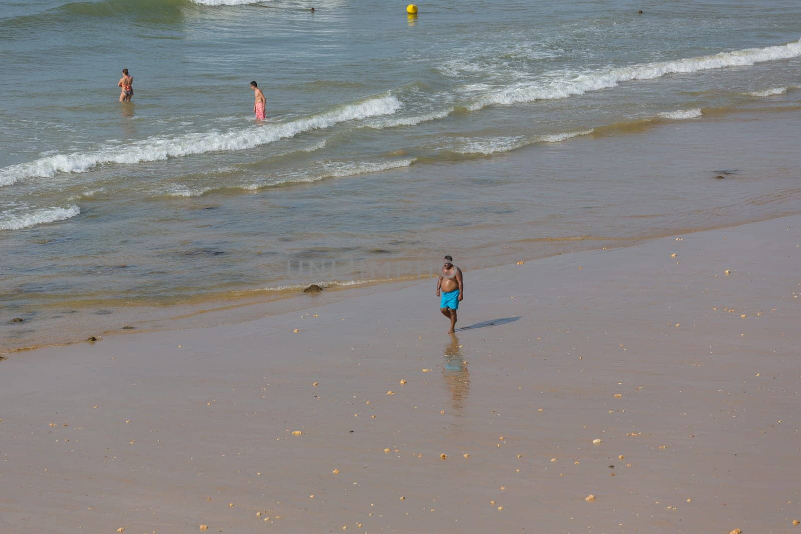 ALBUFEIRA, PORTUGAL - AUGUST 23, 2017: People at the famous beach of Olhos de Agua in Albufeira. This beach is a part of famous tourist region of Algarve.