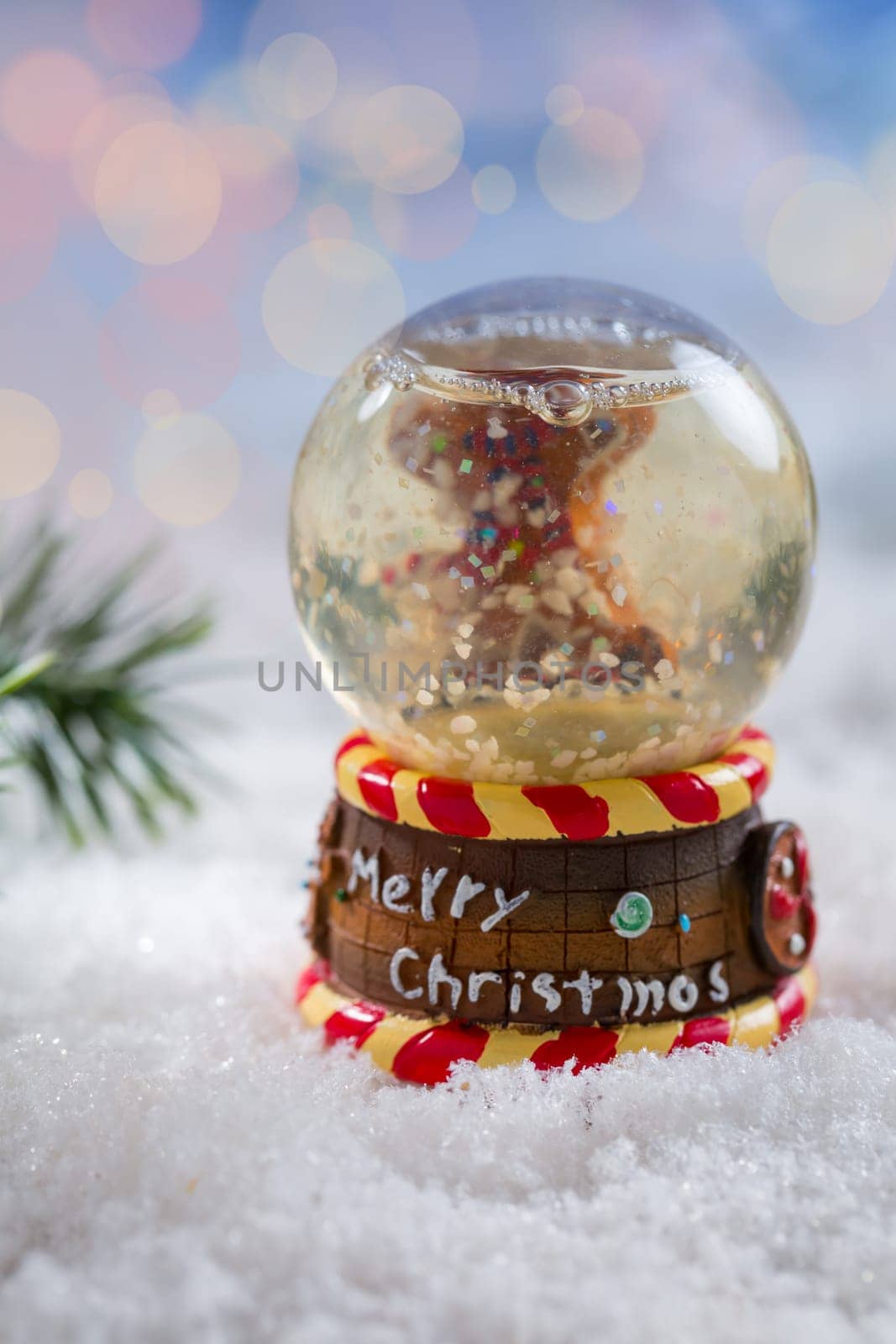 Snowball with branch on snow with blurry background. Symbol of winter and Christmas.