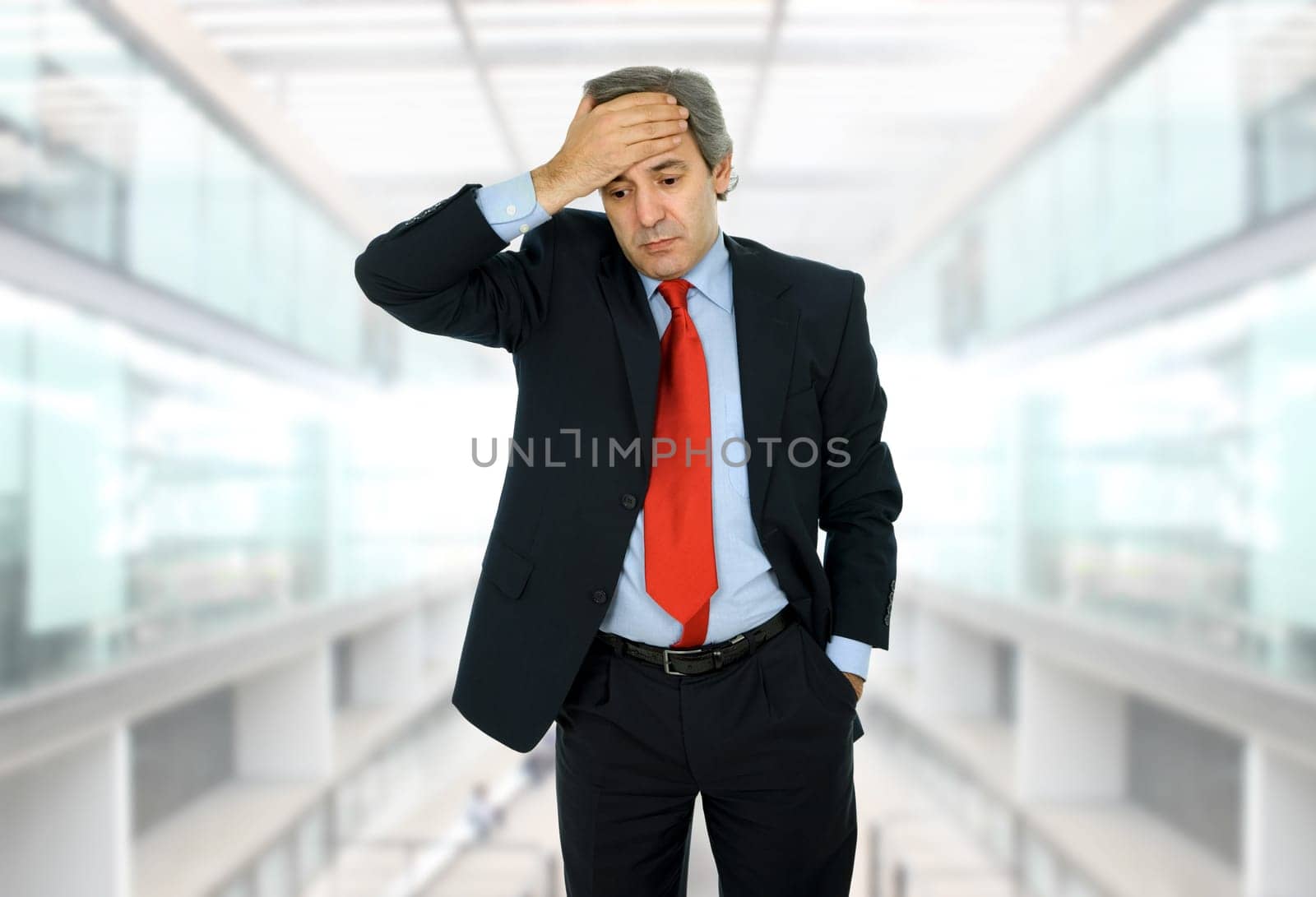 Businessman in a suit gestures with a headache