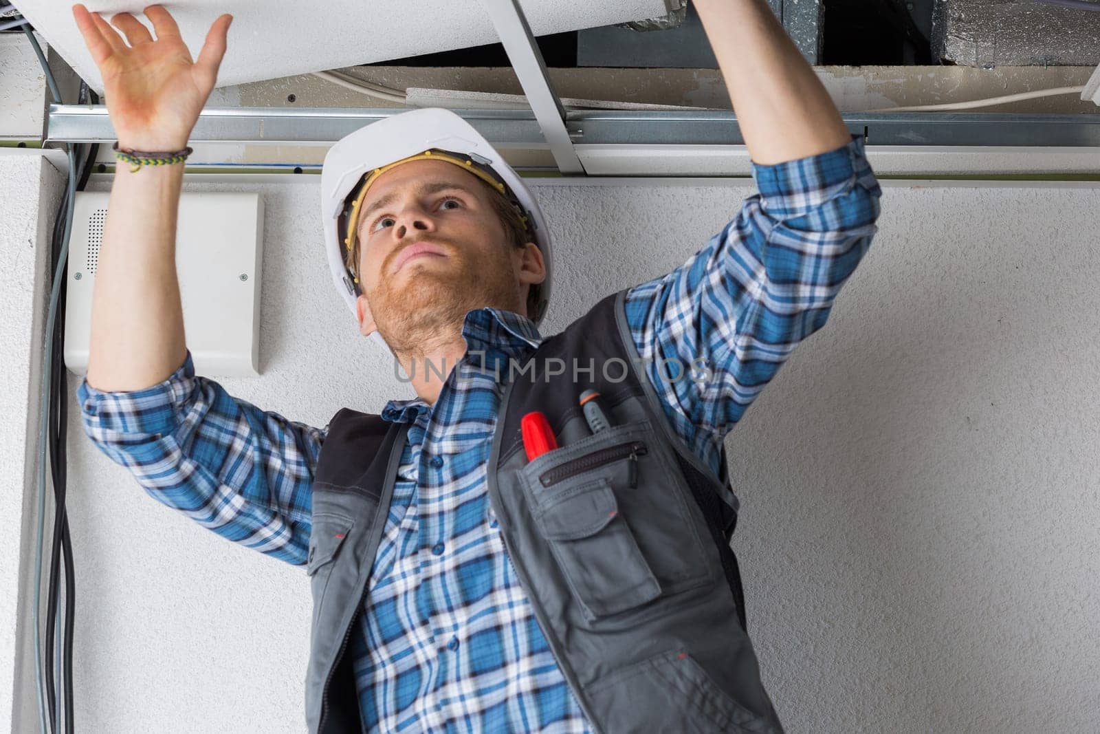 electrical worker wiring in ceiling