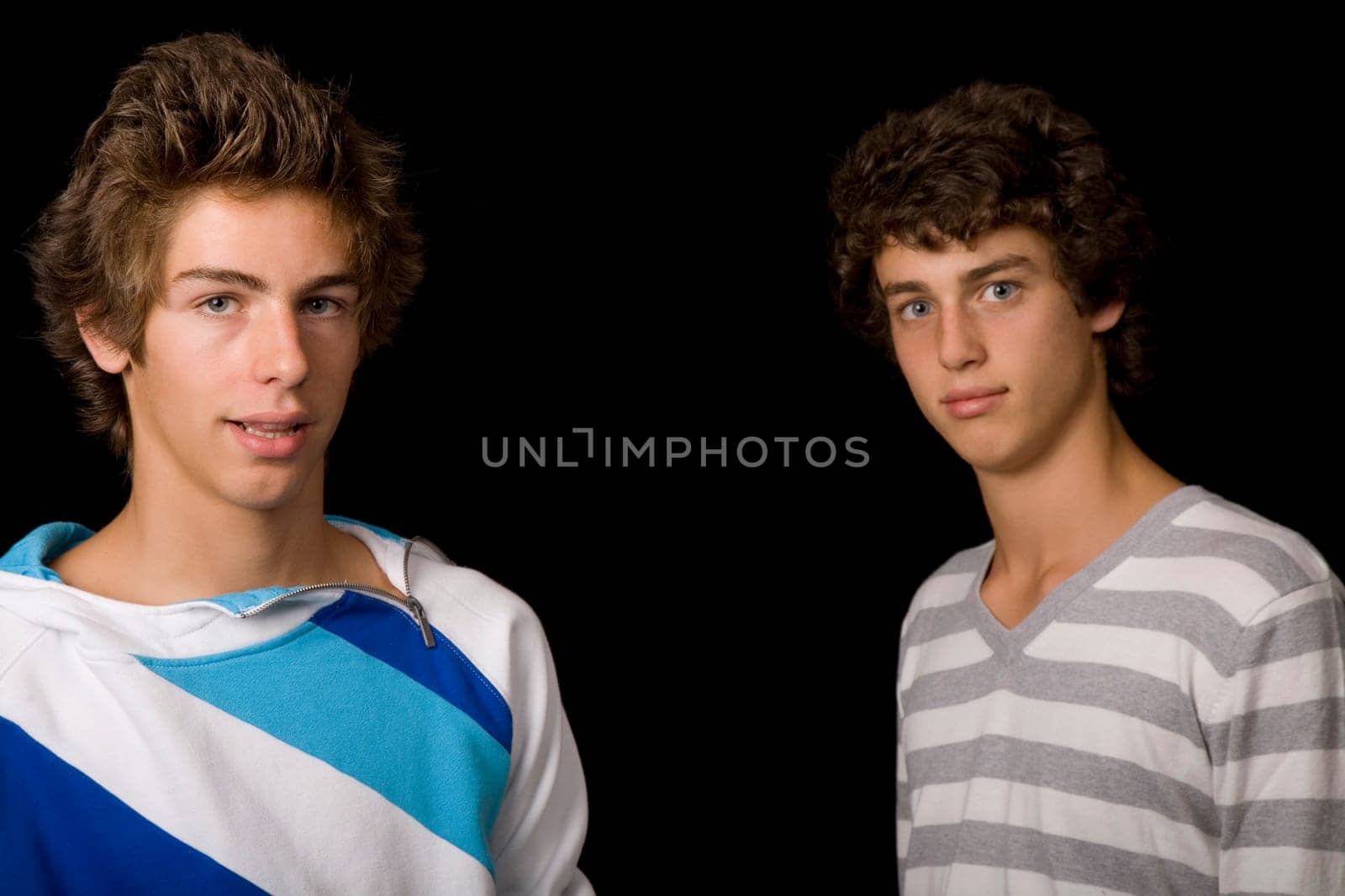 two young men standing, on a black background