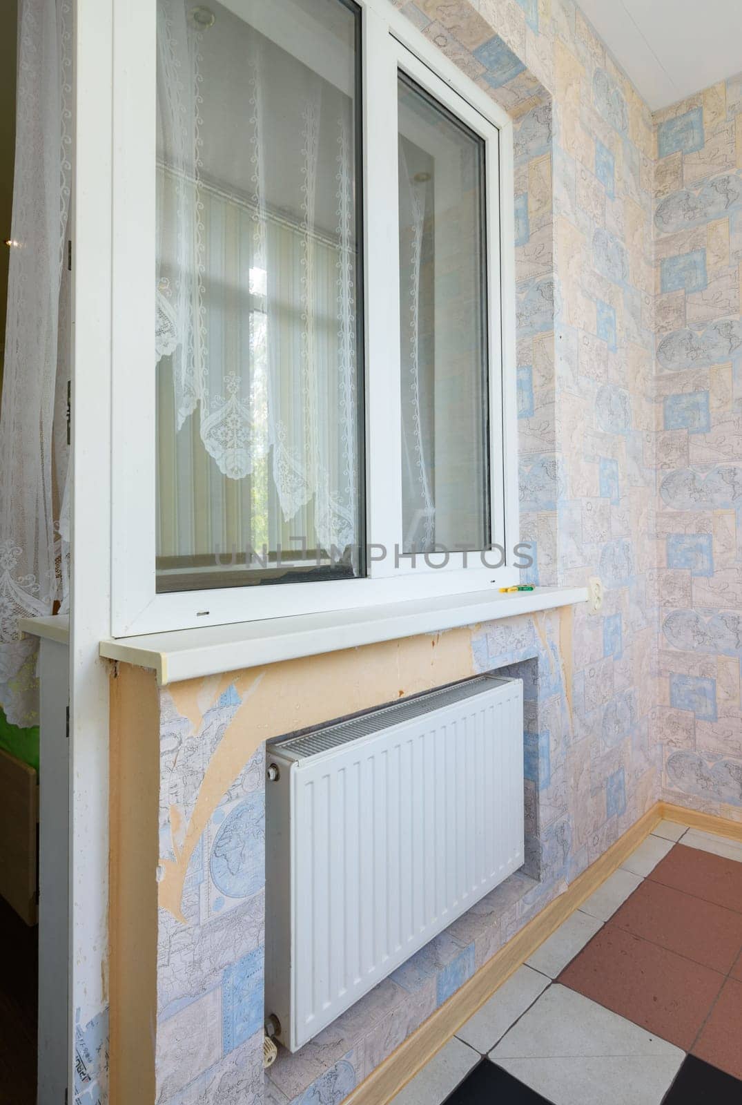 Anapa, Russia - March 3, 2020: Window opening to the balcony glazed with plastic windows, a battery is located under the window