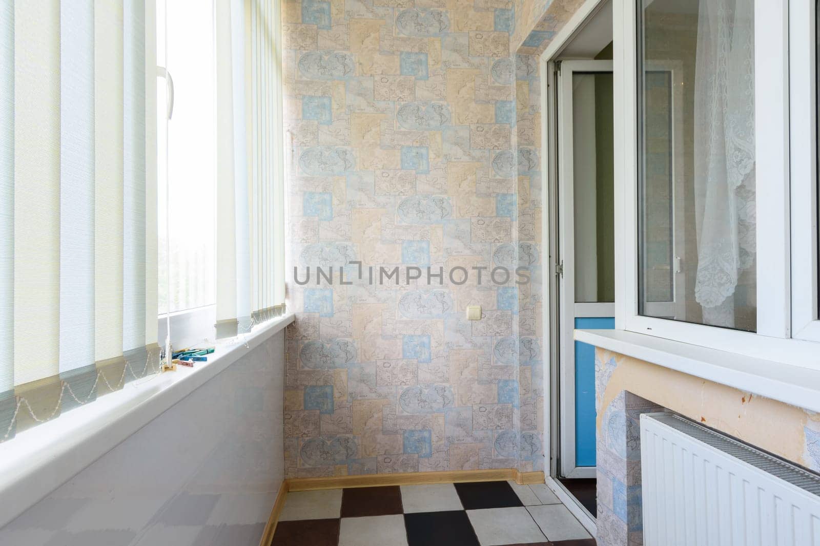 Anapa, Russia - March 3, 2020: Small glazed balcony in an apartment of a multi-storey building, windows are closed with blinds
