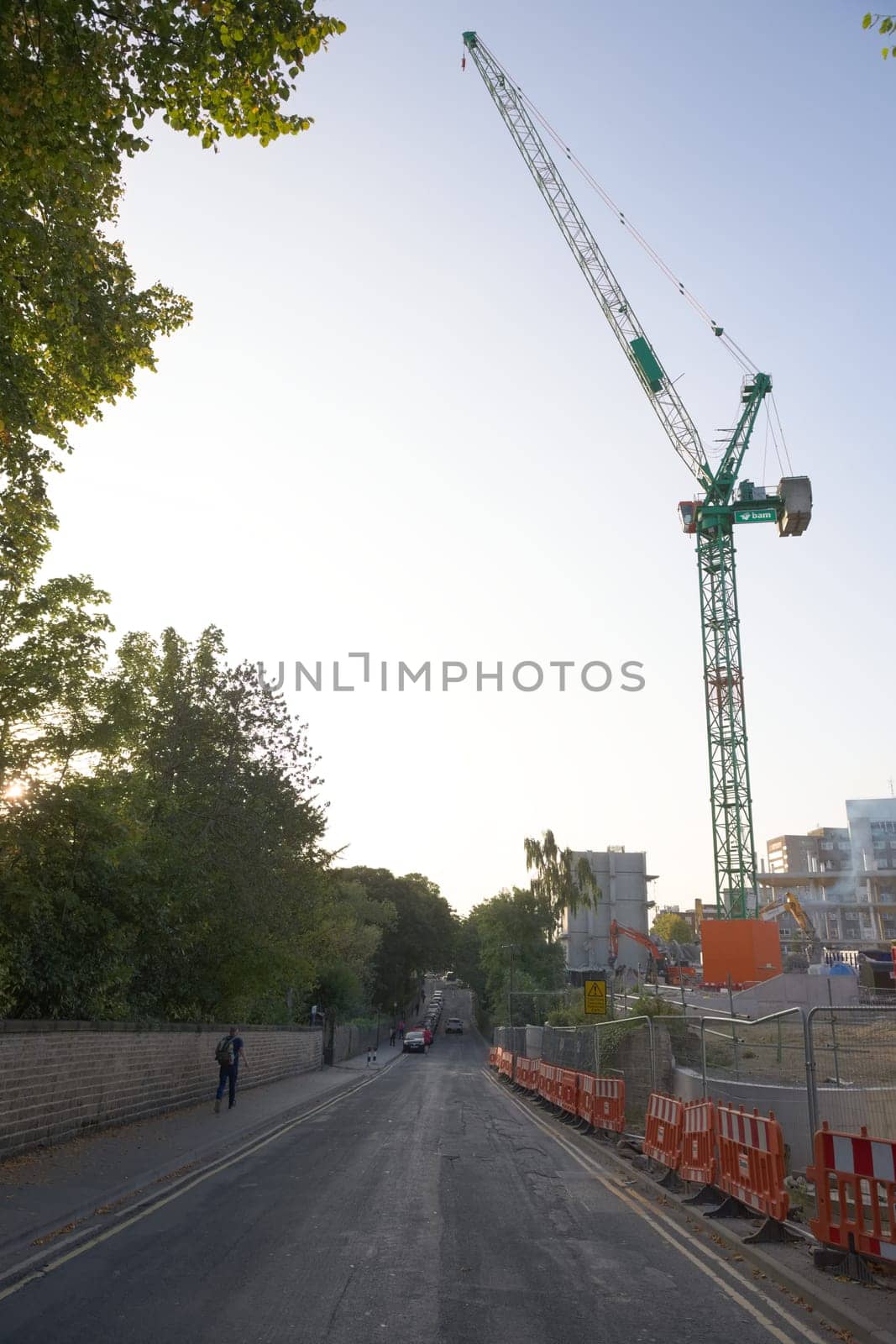 SHEFFIELD, UNITED KINGDOM, 17th September, 2020: Vertical image of green BAM crane overhanging Northumberland road. Sunrise near social science hub.