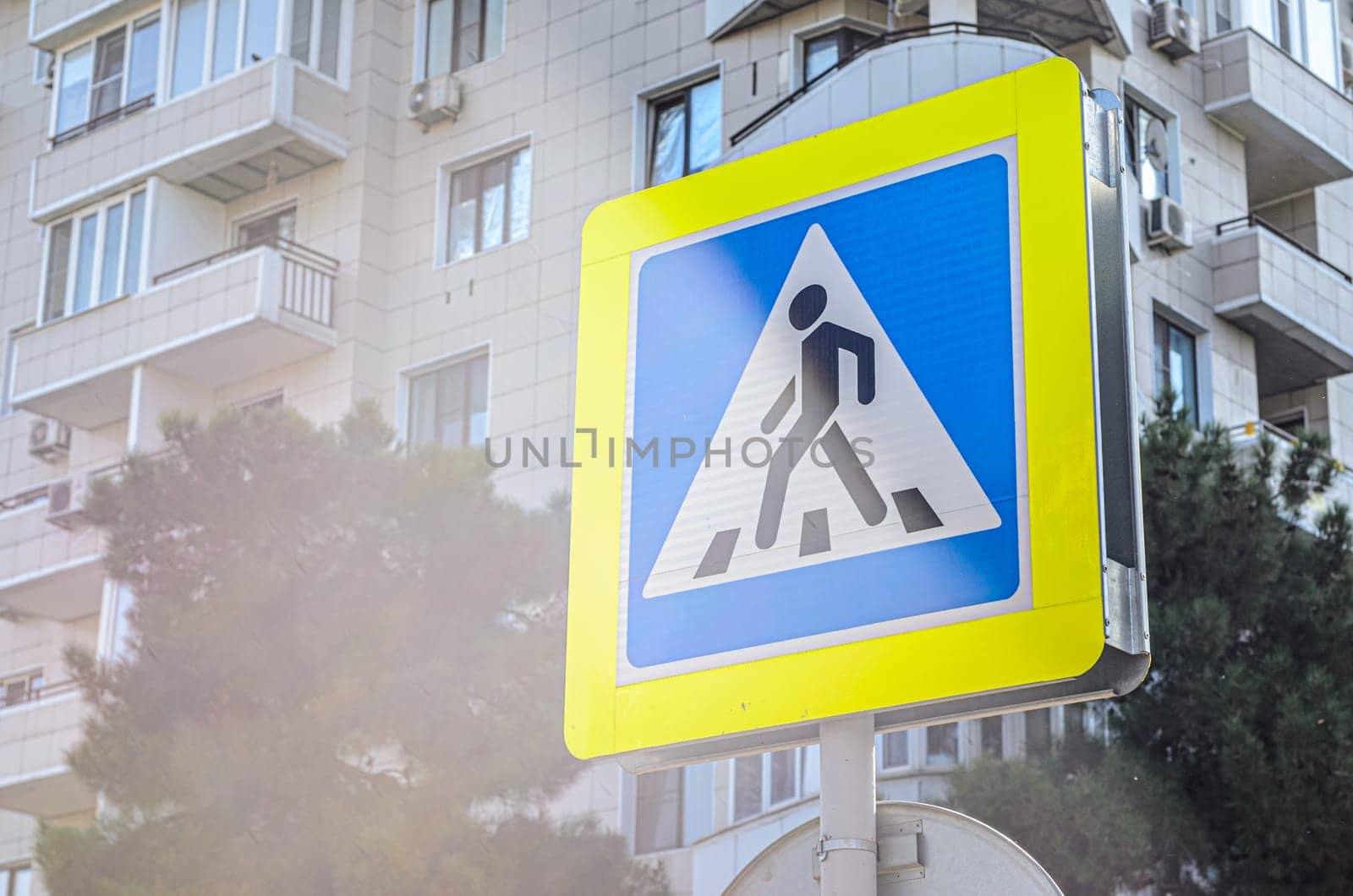 Pedestrian crossing sign on the background of a residential building
