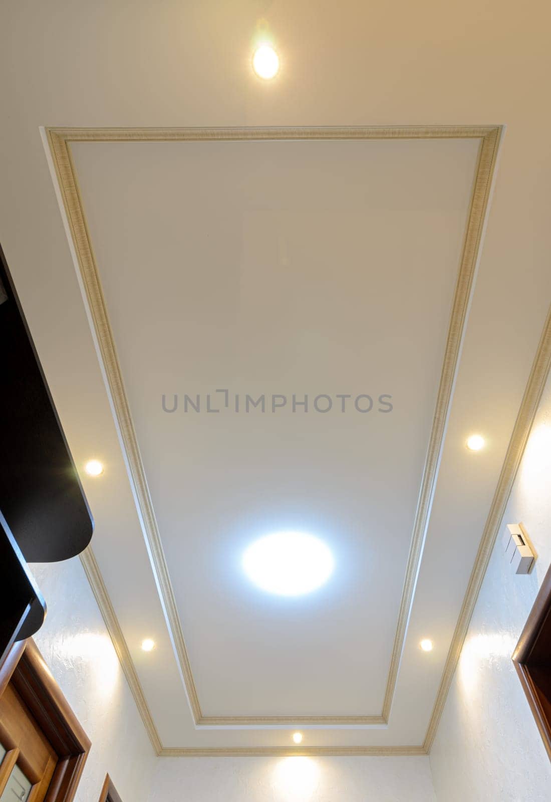 Original stylish multi-level ceiling in the hallway of the apartment