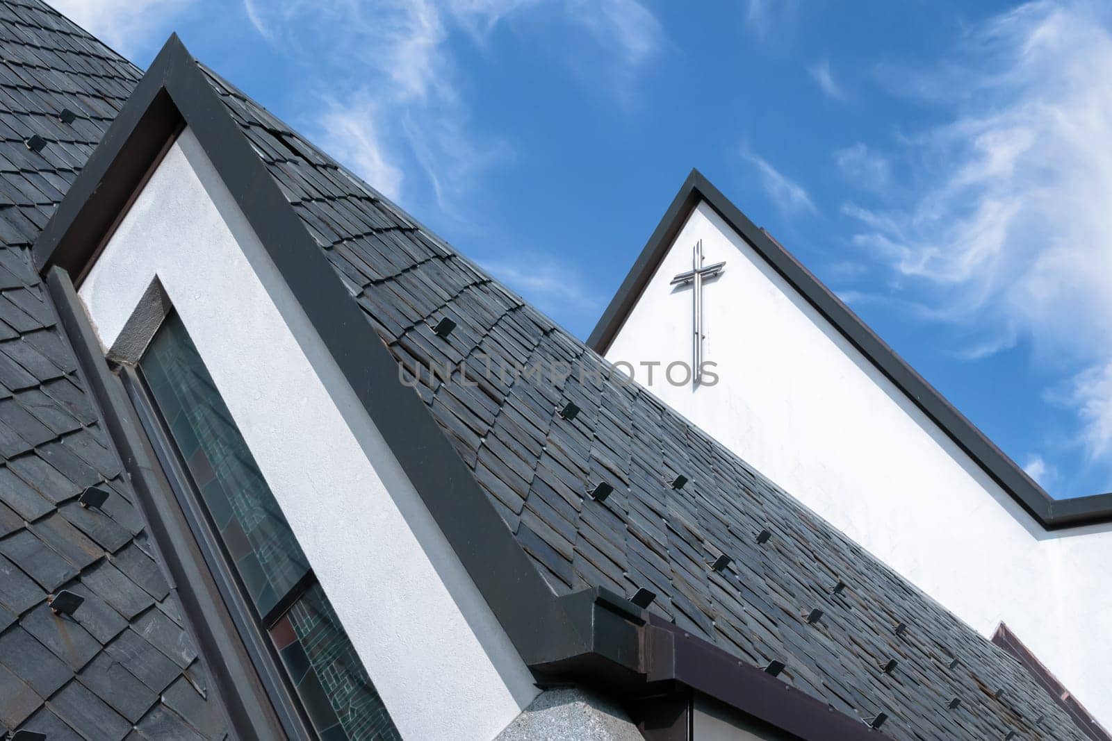Particular roof of an Italian Catholic church. Church roof with angelic blue sky