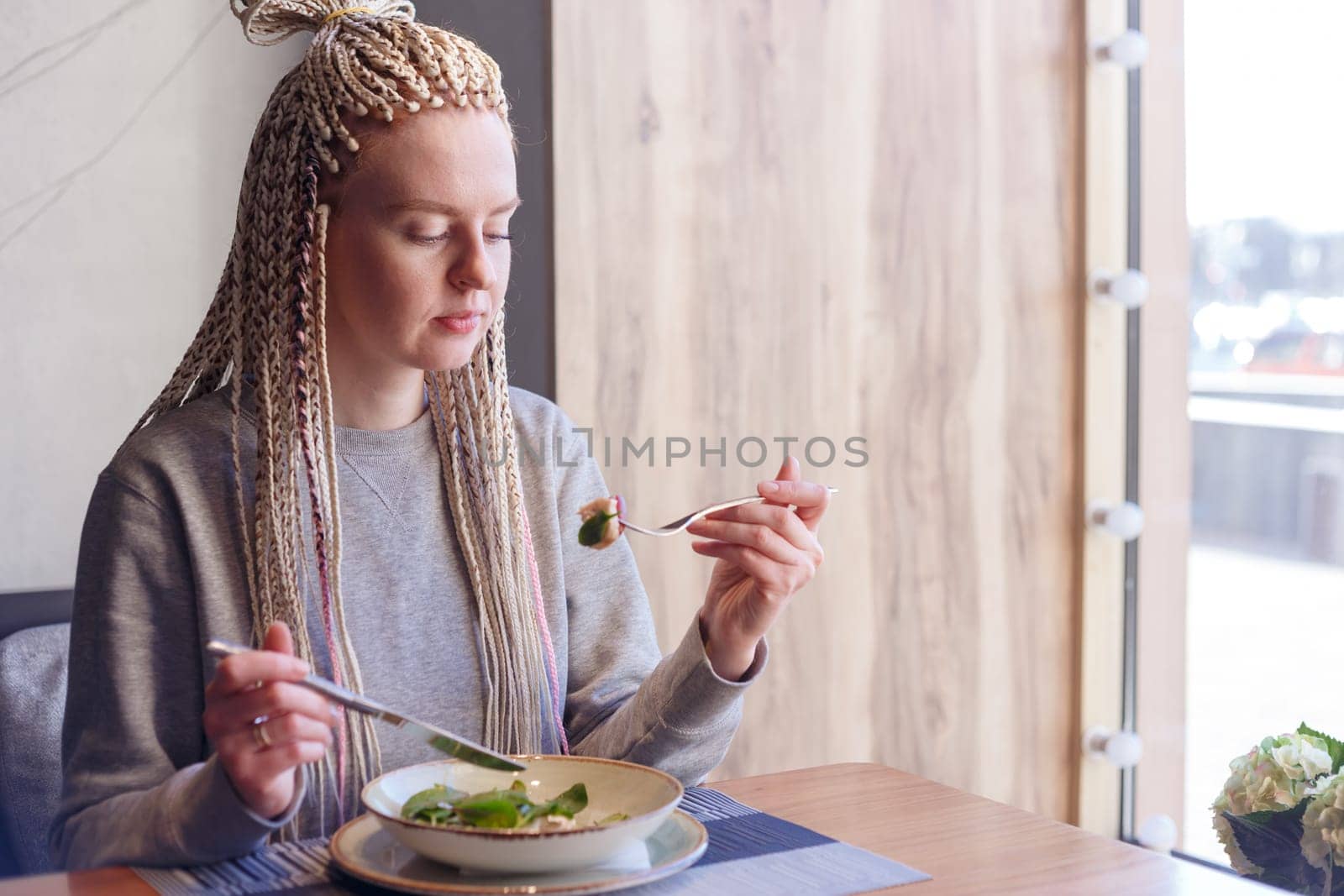 Young attractive woman sitting in a cafe with a salad.