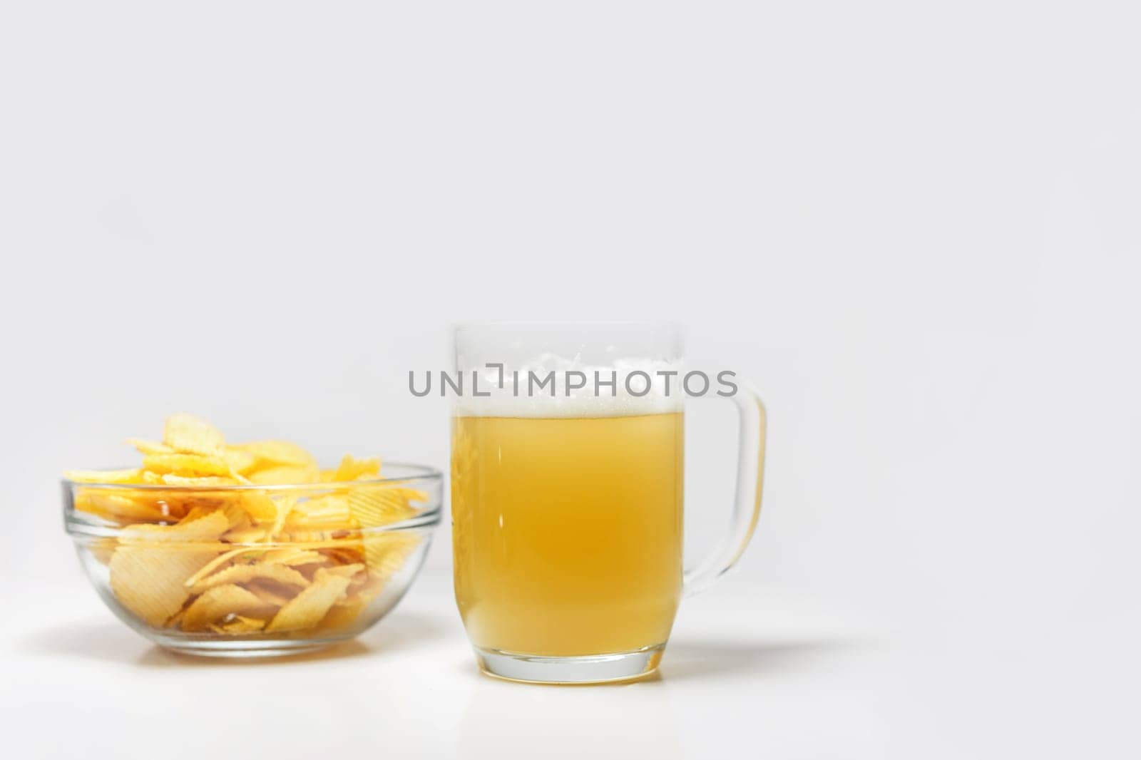 bowl of potato chips or crisps and a glass of wheat beer