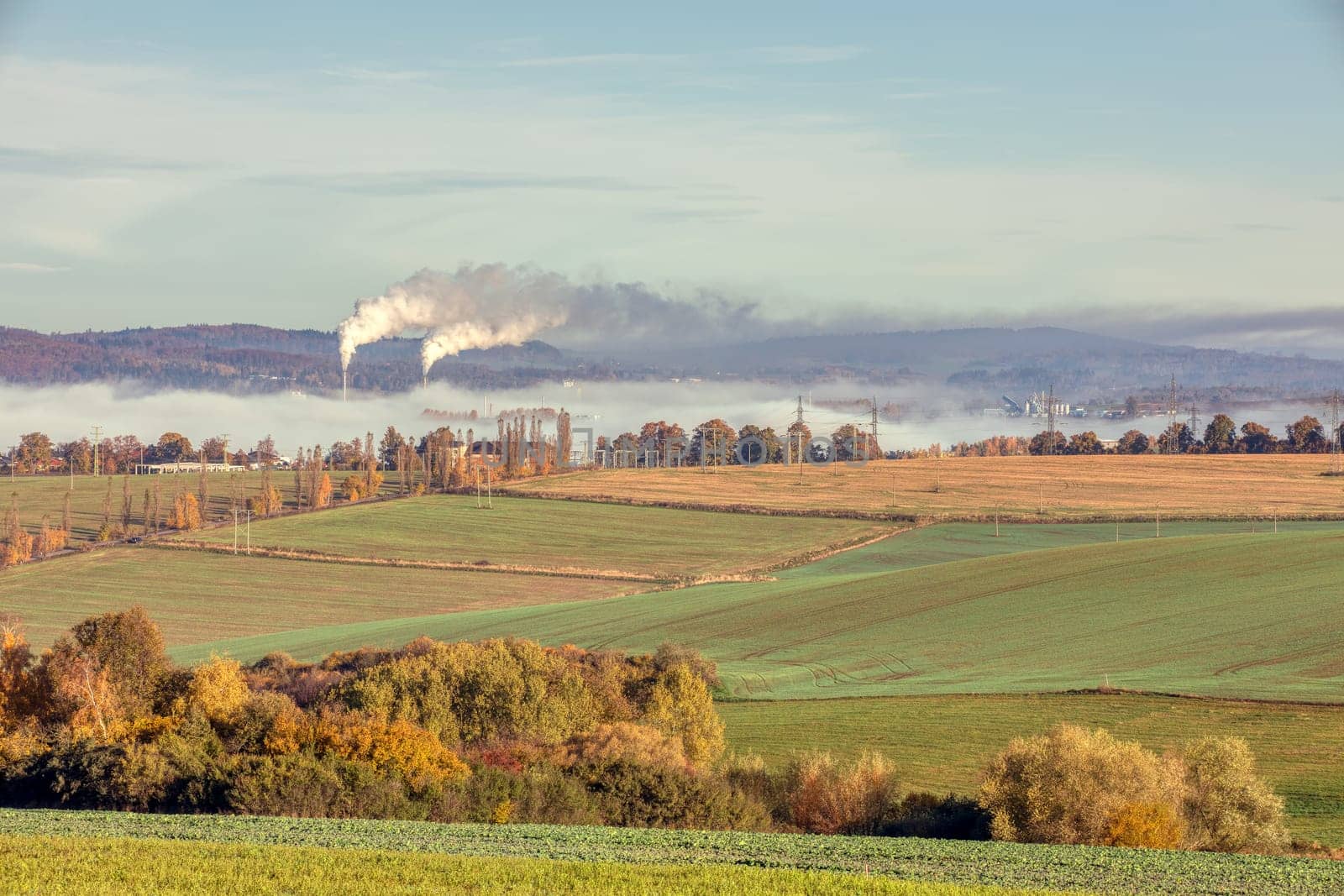 industrial cityscape with with smoking factory, ecology and pollution concept. Autumn fall season with mist. Jihlava Kronospan, Czech Republic