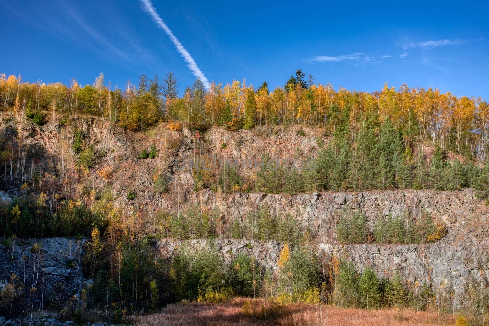 autumn colored trees landscape of abandoned and flooded quarry, Czech Republic