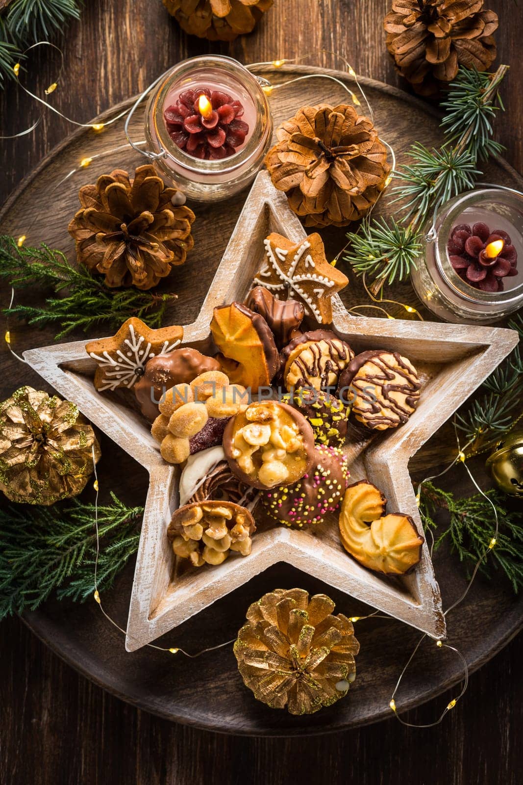 Variation of Christmas cookies and gingerbread with ornaments on wooden background