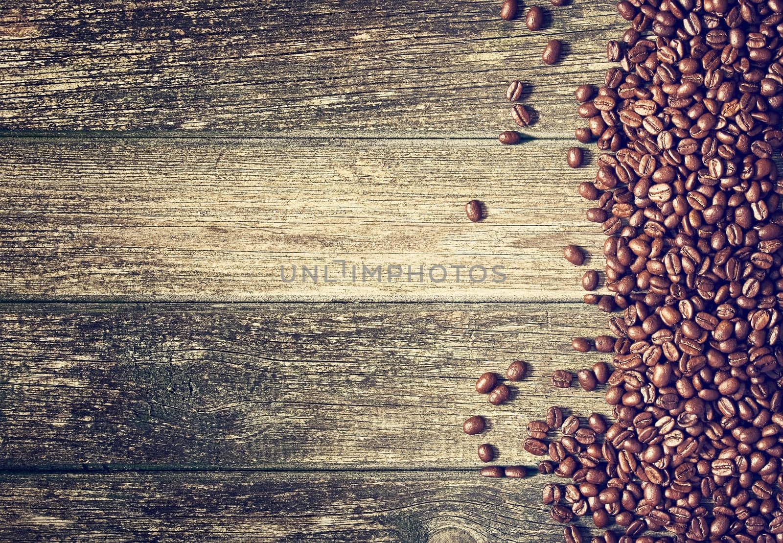 spilled coffee beans on old wooden background
