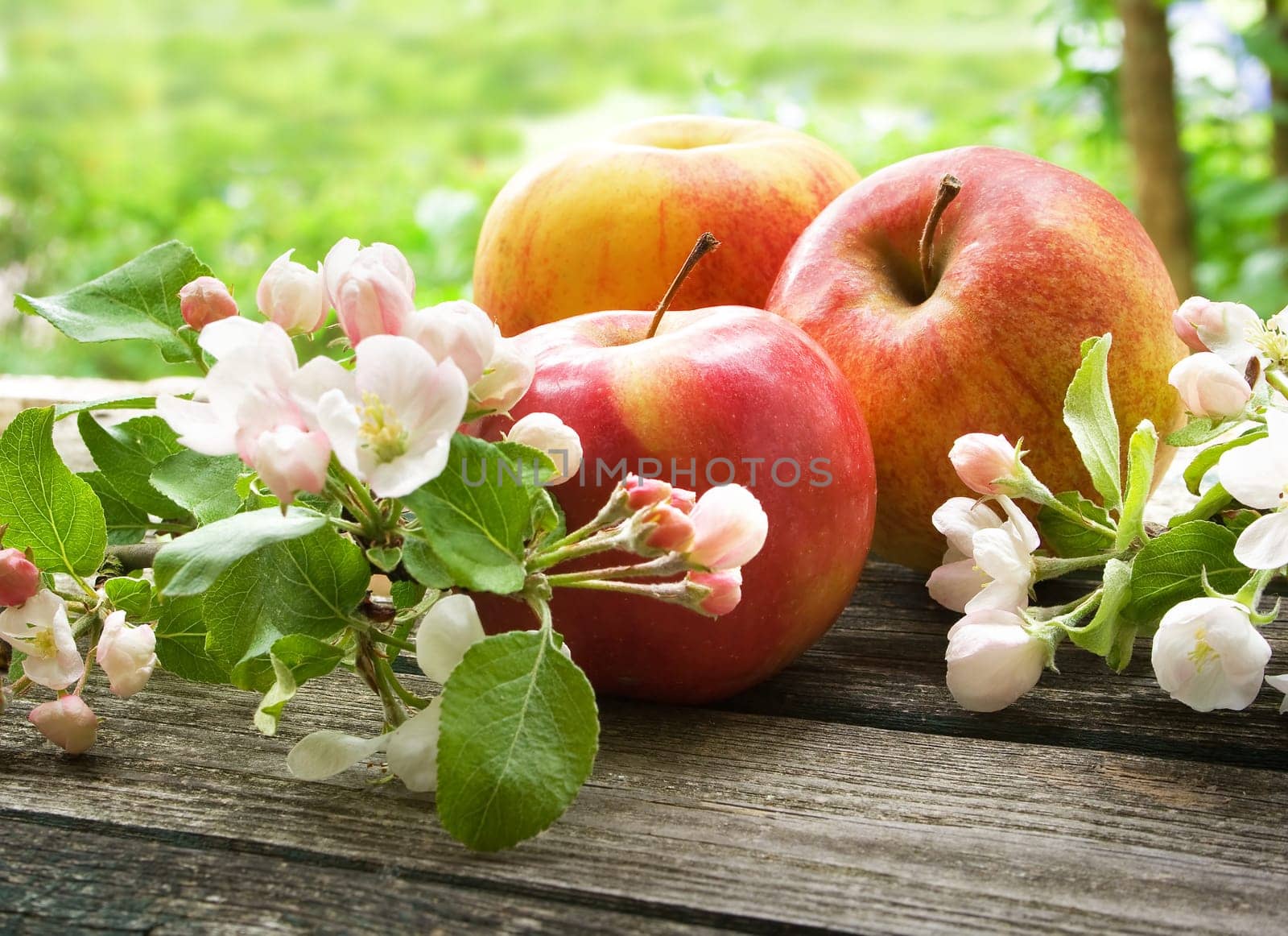 Apple with flowers on wooden board outdoors