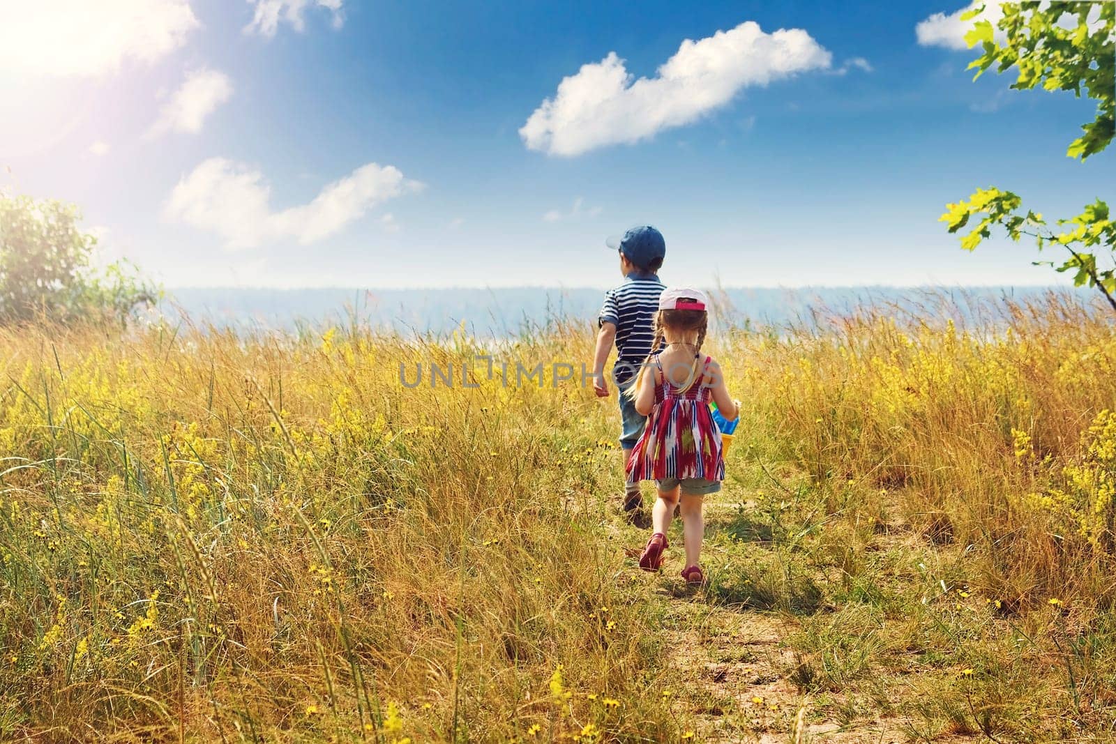 Boy and girl are going to the sea on sunny day