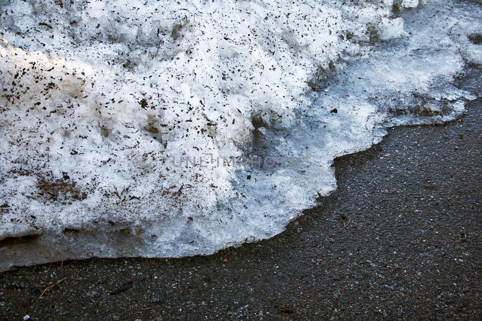 Melting snow on the road in early spring