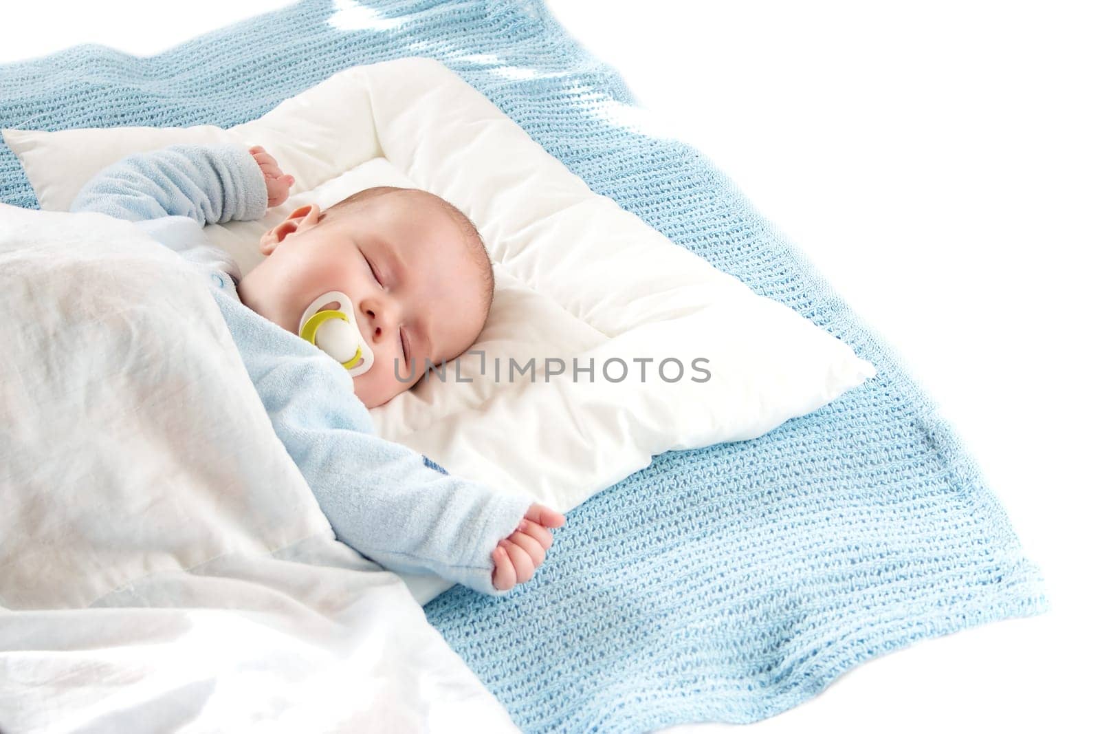 Four month old baby sleeping on blue blanket
