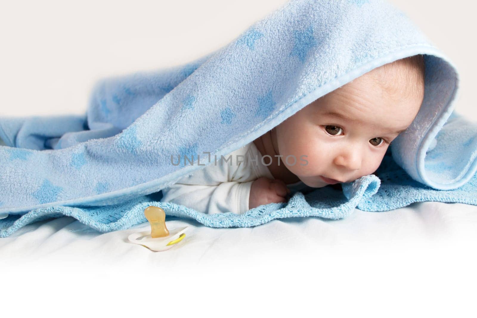 little baby covered with blue fleece blanket