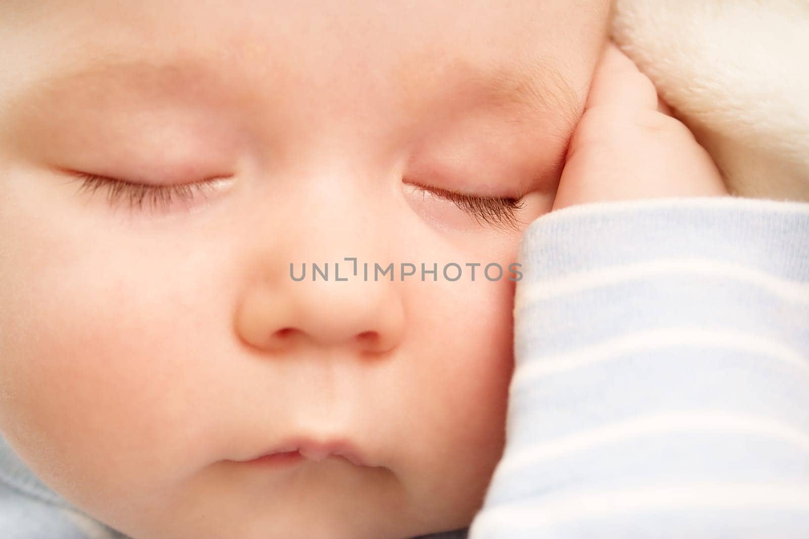 little boy sleeping on soft white blanket
