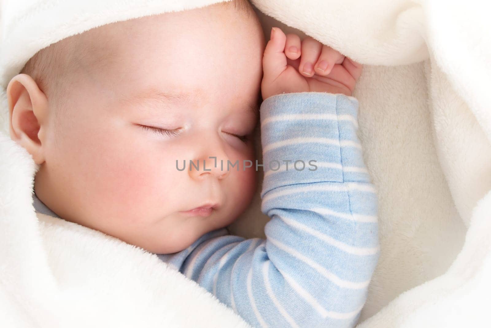 little boy sleeping on soft white blanket