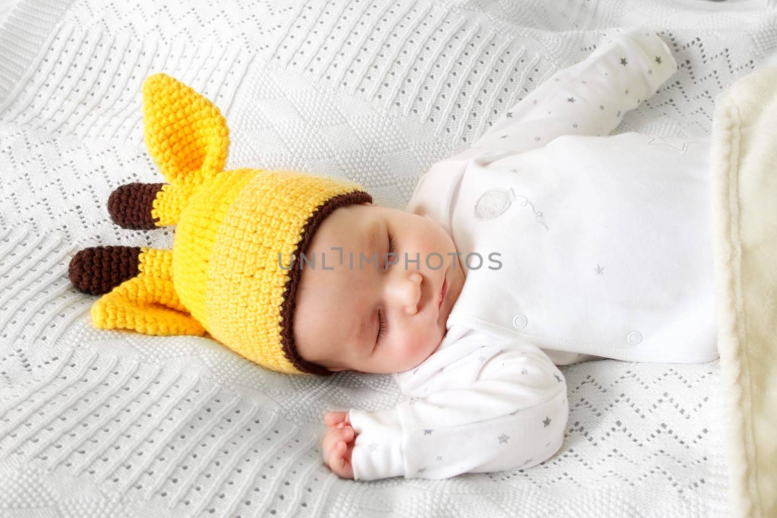 little boy sleeping on soft white blanket